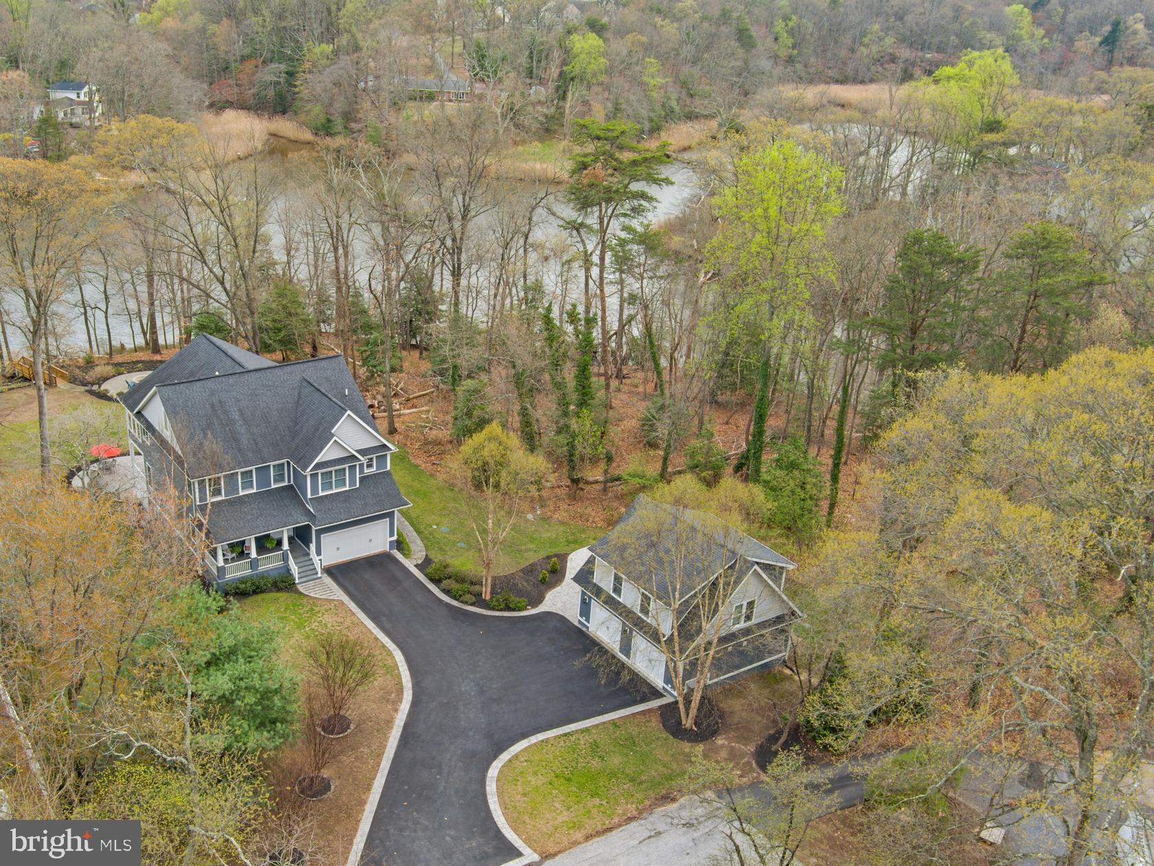This stunning four-story Craftsman-style waterfront home is perfectly positioned on the serene shores of Deep Creek, blending timeless elegance with modern comfort. Step inside to 9'+ ceilings and exquisite details, including coffered ceilings and rich wood floors. The main level features a spacious office/bonus room upon entry and the open floor plan houses the gourmet kitchen with large island, pantry, breakfast nook, a formal dining room, and a cozy living room with a fireplace—all with captivating water views. A conveniently located powder room and mudroom with laundry adds to the home's functionality. Designed for entertainment and relaxation, the lower level boasts a theater room, a welcoming family room with a fireplace, a full kitchen, a bedroom, a full bath, and a laundry/storage room. The walk-out stairs makes for easy access to the stunning backyard and waterfront. The upper level is home to four bedrooms and three baths, including a luxurious primary suite with a coffee bar, two walk-in closets, and a sunroom with panoramic waterfront views. Unwind in your private hot tub and sauna, or utilize the adjacent flex room for endless possibilities. The additional bedrooms include a guest suite with an ensuite bath and two bedrooms sharing a well-appointed bathroom. On the top level, an open-concept space with a kitchenette and full bath provides a versatile area for a guest suite, game room, or private retreat. Outdoor living shines with multiple patios, a firepit, an outdoor fireplace, and a private pier extending into Deep Creek with quick access to the Magothy River and the Chesapeake Bay. The finished detached 2-story garage features an au-pair, guest suite and/or indoor studio. Great additional space to accommodate an overflow of visitors! With 45 feet of waterfront, stunning craftsmanship, and luxurious amenities, this exceptional property offers a rare opportunity to enjoy waterfront living at its finest. Located in the award winning Broadneck school district and close to restaurants and shopping this is the perfect location to enjoy everything the area has to offer including easy access to RT 50 and beyond.  Welcome Home!