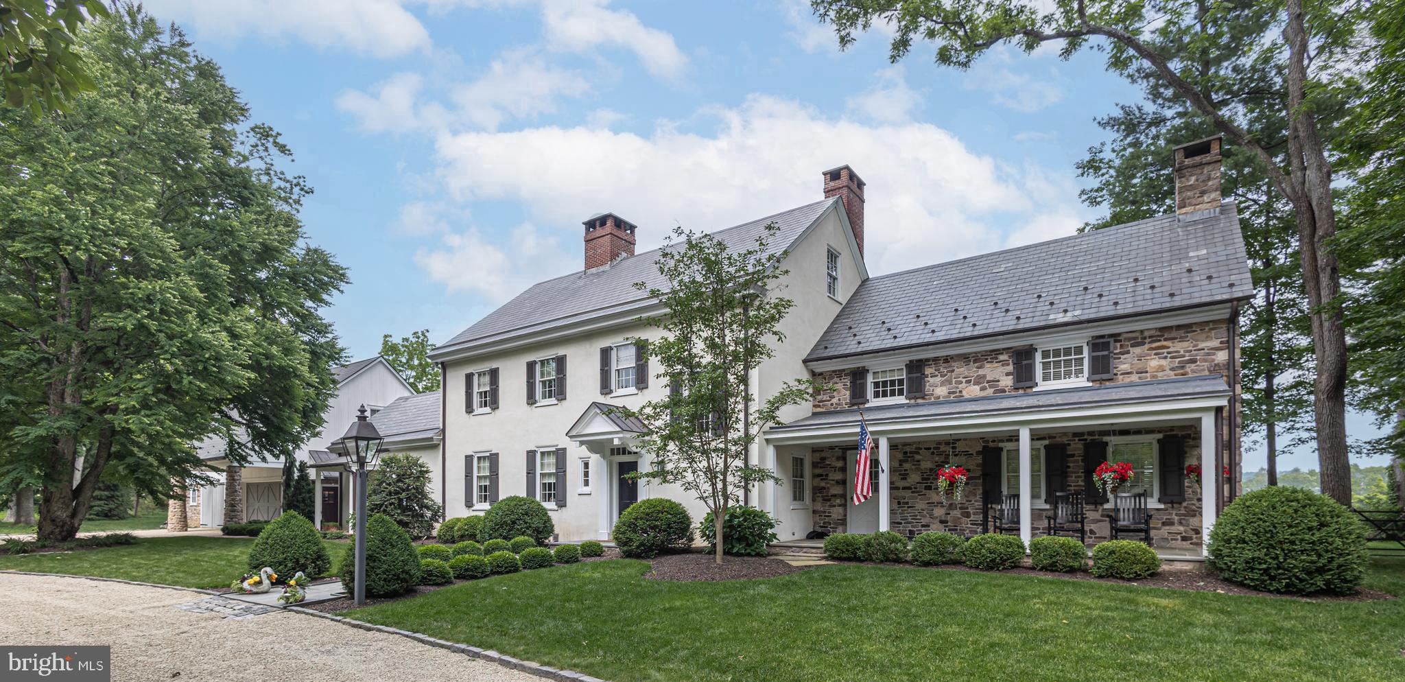 Nestled on 7.5 acres, this custom-built reproduction farmhouse surrounded by mature trees and bordered by fields of open space, blends refined "old world" craftmanship with modern comforts. From the moment you arrive through its private stone walled entranceway, the covered front porch sets the tone. This 5 bedroom, 4 full and 2 - ½ baths residence has been elegantly refreshed and thoughtfully updated throughout. Step inside to discover custom paneling and wainscoting, hardwood floors, mostly throughout, and plenty of sun-drenched rooms on the first floor. As you enter the spacious foyer with its half bath, a stately living room with a wall of built-ins that surrounds a wood burning fireplace graced with Mercer tiles lies ahead. Immediately to the left of the foyer is the family room complete with a stone fireplace. This room flows seamlessly into the gourmet kitchen that is outfitted with Wolf and Sub Zero appliances,  custom-designed cabinetry and a large island with counter seating. Just off the kitchen is the formal dining room with window box seating that overlooks the picturesque backyard and provides outdoor access onto a flagstone patio. Also on this level is a private office and a first floor bedroom with an en-suite bath and 2 cedar closets, In addition, there is an over-sized laundry/mudroom with its own half bath. Upstairs is the primary bedroom suite with a vaulted wood ceiling, a walk-in-closet and an en-suite bath with dual vanities and an oversized walk-in shower. The second floor also offers three spacious bedrooms, one with an en-suite bath and walk-in closet, while the two remaining bedrooms access the hall bath. The third floor is a new open high-ceiling space with large windows perfect for an office, entertainment or game room or additional bedroom with sitting area. An unfinished walk-up basement with 9' ceilings and multiple rooms provides ample storage. Beyond the interior, discover outdoor living at its finest. Step outside and onto one of three beautiful bluestone terraces, perfect for family gatherings and barbeques or to just take in the gorgeous long-distance views the property has to offer. Features include:  summer kitchen with built in Wolf grill, sink,  refrigerator, and soapstone tops,  and perennial gardens.  Close proximity to the home and a lovely heated salt water pool is a newly built detached carriage house which provides on one side an outdoor covered space perfect for alfresco dining and on the other side a 3-car garage. Above the carriage house is living space of about 1,160 s.f.  that has been outfitted with a full custom designed kitchen, Wolf and Subzero appliances, living room, bedroom with its own full bath and laundry room, perfect for multi-generational living or guest accommodations. Whether you're enjoying the peaceful surroundings or heading out to nearby spots like New Hope or the Delaware River, you will enjoy this home's blend of tranquility and convenience. This property offers privacy and a one- of- a- kind setting within the award-winning New Hope­ Solebury school district. An extraordinary opportunity to own a charming residence in one of the region's most sought-after locales.  Schedule your private tour today.