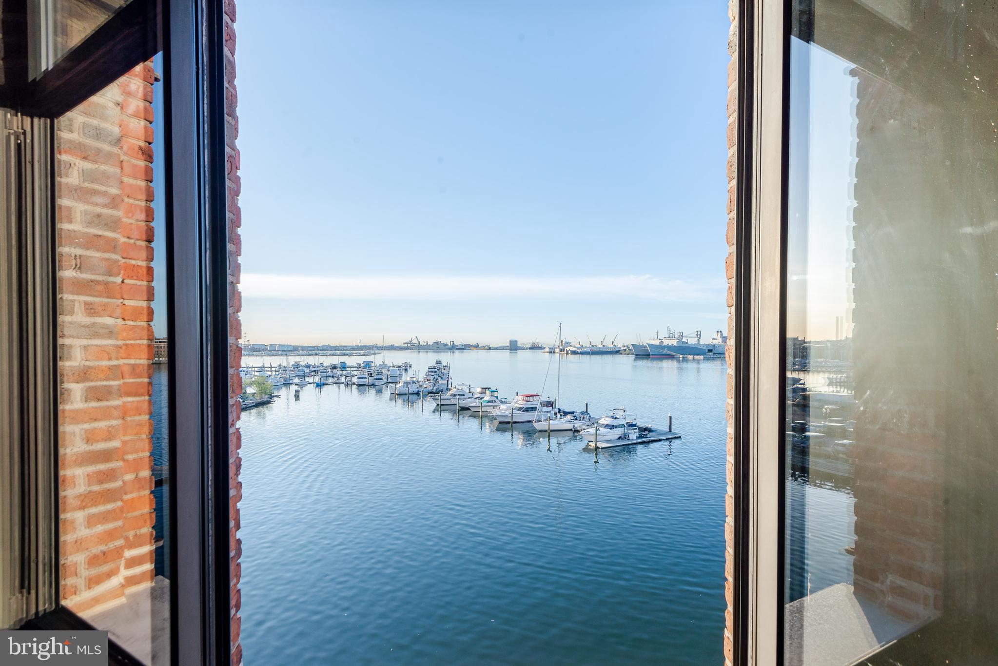 Waterviews, casual elegance, exposed brick walls, welcome to one of the most unique waterfront condominiums in historic Fells Point. This two-bedroom, two-bath single-level condominium has over 1,700 square feet of the most luxurious living that Baltimore has to offer.  Enjoy spectacular unobstructed water views from the Key Bridge to the Baltimore Inner Harbor skyline.  Wake up to beautiful sunrises and relax at the day’s end watching colorful sunsets from your windows.  Renovated throughout, this open floor plan boasts a gourmet kitchen with high-end appliances including double ovens, raised ceilings with special lighting, updated baths, hardwood floors, and exposed brick walls. Owners added a custom wall unit in the Living Room and custom closets in both bedrooms. Enjoy watching everyday boat traffic in the Inner Harbor, including sailboat races and ships docking at several working piers, as well as some of the best views of the city’s many harbor events such as fireworks displays, Blue Angel shows, visiting tall ships, and holiday boat parades.