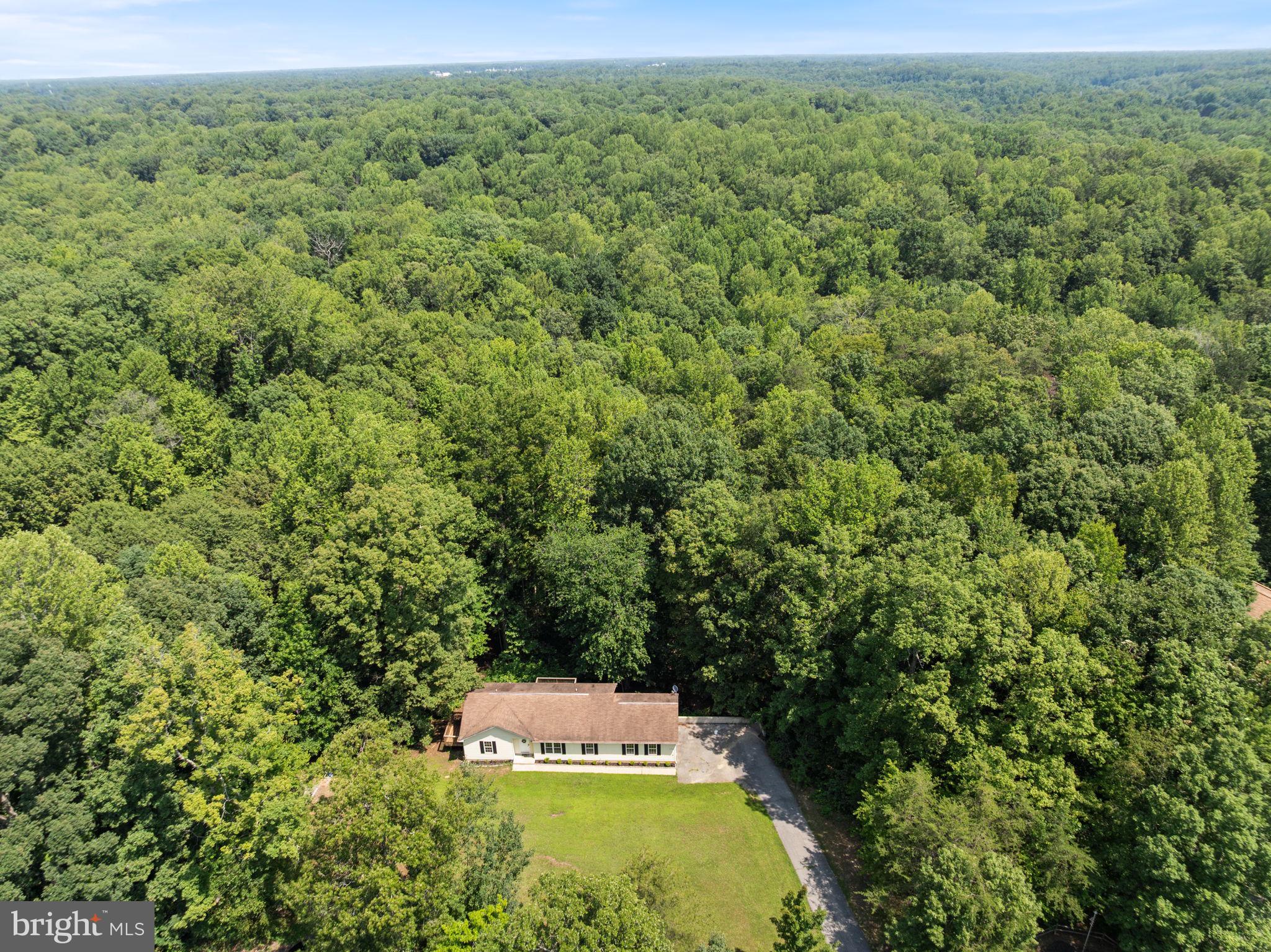 Looking for privacy while still being close to shopping, restaurants, and everyday conveniences? Welcome to this beautiful ranch rambler with basement located in the desirable Country Lakes community of Mechanicsville. Nestled on 3.65 mostly wooded acres with a peaceful wooded backdrop, this property is a nature lover’s dream. This well-maintained home offers 3 bedrooms, 2.5 bathrooms, and a spacious 2-car garage. The main level features laminate flooring throughout most of the home, creating a warm and inviting feel. The primary suite includes a relaxing garden tub and access to one of two private decks where you can enjoy the peaceful surroundings. The unfinished basement provides endless possibilities for additional living space, storage, workshop space, or future expansion and already includes a convenient half bath. Residents of Country Lakes enjoy wonderful community amenities including baseball and softball fields, tennis courts with evening lighting, basketball court, playgrounds, picnic areas, and a covered pavilion perfect for gatherings and outdoor enjoyment. If you’ve been searching for one-level living with privacy, acreage, and community amenities all in one, this home is a must-see before it’s gone!