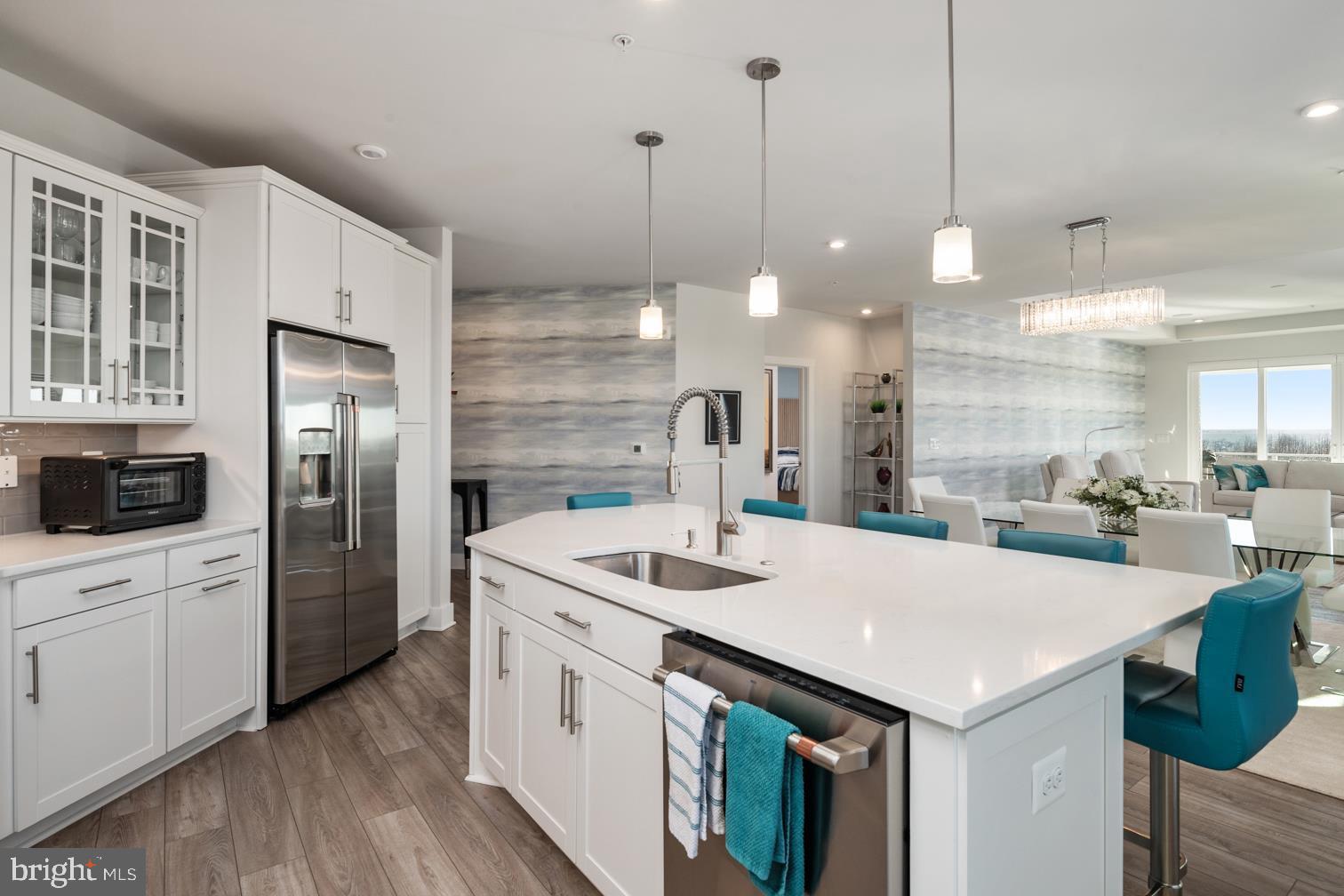 Four Seasons at Kent Island is an active 55+ community on Maryland's Eastern Shore, offering island resort-style & maintenance-free living at its finest! This Severn model is a spacious and airy 3 bedroom, 2.5 bath penthouse, end-unit boasting an expansive open floor plan with over 2600 square feet of luxurious living space. This home features a lavish gourmet kitchen and dining area, a huge great room with sliding door access to a large corner balcony. 
As you enter this home through an inviting foyer you have direct access through French doors to a home office/guest bedroom. 
The distinguishing features of this home include a state-of-the-art kitchen equipped with GE Energy Star stainless steel appliances, multi-functional range top with a Wi-Fi Connect Enabled hood, upgraded quartz countertops, oversized center island with pendant lighting, upgraded staggered custom cabinets with slide out drawers and brushed nickel hardware. Whether you’re preparing a quiet meal for two or hosting a lively gathering, this kitchen is as functional as it is beautiful.
The homes’ dining and living areas extend from the kitchen with an open, yet intimate layout, bordered with oversized windows allowing for lots of natural light.  Levolor Cellular Shades provide light control and privacy, when needed. A very special feature is the  Surround Sound Home Theater with an 85 inch flat screen TV. The entire home theater will be yours to enjoy.
The fantastic owner's suite boasts a decorative wall mounted designer panel, has an adjoining sitting room with access to the balcony, an owner's spa bath and 2 oversized walk-in closets. 
Two large secondary bedrooms are located in a separate wing of the home and each feature a walk-in closet and share a Jack and Jill bath. This section of the home has a separate laundry room with built-in cabinets and a GE SMART washer and dryer. 
Special features throughout the home include custom closets by Closet America, Candice Olson wallpaper, black-out blinds in all bedrooms, remote control blinds on slider leading to balcony, and tray ceilings throughout the home - a benefit of being a penthouse unit. Quartz countertops and luxury ceramic tile are included in all baths.
This home also has the LARGEST garage in the building, and the LARGEST storage room in the building,  which is a few short steps from the elevator. 
This MUST SEE condominium is ready for immediate delivery and shows better than a model, better than new – the thought, planning and design that have gone into this home is second to none!
KEEP IN MIND THIS SEVERN MODEL, WITH OVER 2600 SQUARE FEET OF LUXURY LIVING SPACE, IS AVAILABLE TO YOU NOW. PRESENTLY, THERE IS A 7-10 MONTH WAIT FOR THE COMPLETION OF NEWLY CONSTRUCTED SEVERN MODELS, BUT THIS UNIT IS MOVE-IN READY WITH PLENTY OF HIGH-END DESIGNER FEATURES AND UPGRADES ALREADY INCLUDED.  Award winning 24,000 Square Foot Clubhouse with Stunning Chester River Views! Fantastic amenities include an  infinity pool, indoor pool with, fitness center, library, game room,  fire pits, tiki bar equipped with refrigerators, sinks and television monitors, pier with transient boat slips, walking paths that link to the Cross Island Trail, pickleball & tennis courts, bocce, dog park, and an outdoor amphitheater for live music and movie nights. The community lifestyle director will keep you busy with daily activities such as yoga, a variety of exercise classes and an assortment of clubs including biking, billiards, book club, baking, mahjong, environmental club, trivia night and more. In addition to the weekly and monthly activities, residents can enjoy crab feasts, and holiday gatherings throughout the year. This development is an unrivaled, amenity-filled, resort-style experience with convenient access to Annapolis, DC, Baltimore, and BWI. Kent Island offers multiple dining and shopping options, a nearby outlet mall, and a 6.5 mile cross-island trail surrounded by views of the Chester River.