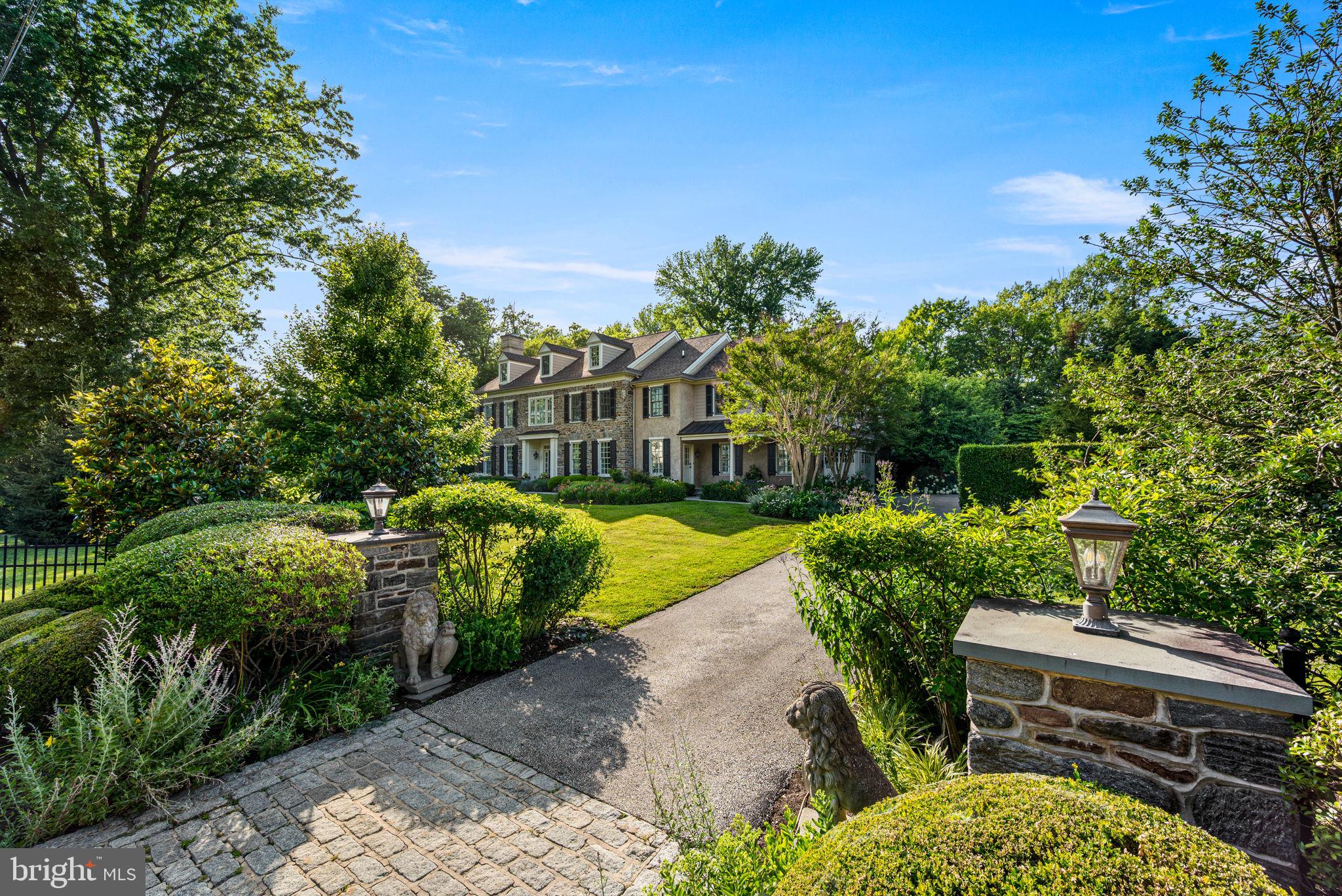 Exquisite Stone Colonial Manor Home in the prestigious Estate Section of Devon with over 7,500 square feet of exceptionally finished living space, situated on a beautiful prime acre of professionally landscaped grounds on a private corner lot with an oversized  pool and hot tub! This home was creatively designed and built by Ted Babiy and exudes impeccable craftsmanship in every detail including large arched cased openings to formal rooms, crown mouldings galore, walls of wainscoting, vaulted ceilings, lovely built-ins, and curved walls. Prepare to be amazed as you step inside this fabulous house designed for grand scale entertaining and busy day-to-day active living.  Approaching the front entrance with a stunning stone facade, a stone walkway is lined with beautiful and mature plantings. A handsome front door with sidelights and a transom window leads to the elegant front-to-back Center Hall that boasts an open 2-story turned staircase with a large landing to the Second Floor and a hall to the formal (1 of 2) Powder Room with a tasteful furniture vanity. The front of the Center Hall is flanked with two arched cased openings to the Living Room on the left and the Dining Room on the right. Gorgeous hardwood floors flow throughout these rooms as well as the Study/Gathering Room adjacent to the Living Room, and all have oversized crown mouldings. The formal Living Room is complete with a lovely gas fireplace with black marble surround and hearth and is encased with floor-to-ceiling wainscoting. The formal Study with French doors to the rear of the Center Hall is currently set up as a cozy Sitting/Gathering Room for intimate conversations and boasts walls of windows including a bump out/nook. The formal Dining has beautiful wainscoting and convenient access to a Butler’s Panty complete with marble wet bar and built-in cabinetry. The recently renovated state-of-the-art Kitchen is an absolute must see! Cleverly designed with “stations” for various activities/needs, it offers timeless cabinetry with refreshing- not your ordinary- quartz counters, a large island with seating and additional sink, one-of-a-kind oversized refrigerator/freezer with wine refrigeration in the middle, water purification for healthy modern living, two dishwashers, a 6-burner gas range, double wall ovens, one with a steamer, under counter built-in microwave, appliance cabinet with built-in counter, separate standing Scotsman icemaker, and a beverage refrigerator. There is also a built-in desk area with standing desk and printer stand! Everything was thought of to make the most functional Kitchen! The Kitchen is open to the Breakfast Room with a vaulted ceiling and French doors to the outside terrace/pool/hot tub oasis as well as the Great Room/Family Room. The Great Room offers a wall of built-ins for your entertainment needs, a gas fireplace with slate surround and raised slate/stone hearth with traditional wood mantle and glass doors, a magnificent Palladian window, and French doors to the Terrace for outdoor dining. There is a Rear Hall with multiple closets, an  informal Powder Room, and a Mud Room with beadboard walls and built-in bench seating. The Second Floor is home to a luxurious Primary Bedroom Suite complete with Sitting Room, fully outfitted walk-in closets, and sumptuous Primary Bath, 4-5 additional Bedrooms and Suites all with hardwood floors, one of which has built-ins and is currently used as an Office, 3 additional full Bathrooms, a large walk-in Linen/Storage Closet, and the Upstairs Laundry Room (1 of 2).  The Third Floor has a large finished Recreation Room with two built-in window seats as well as built-in shelving, a large Storage Room, and Attic space. The Lower Level is sprawling and includes a Game Room, 2nd Family Room with what could double as a 2nd Kitchen (dishwasher, sink, cabinetry), Exercise Room, the 5th Full Bath and 2nd Laundry Room, an enormous Storage Room, and finally an outside entranceto the Pool & Rear Grounds.