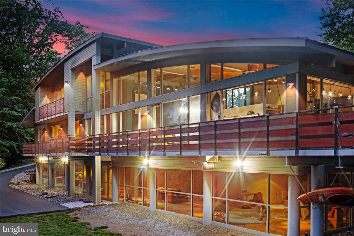 BESPOKE! Feast your eyes on the epitome of quality construction and cosmopolitan style in this creative 2008 Bauhaus designed residence! The property is an engineering marvel with a sophisticated GEOTHERMAL system which provides energy efficiency for both people and the environment. Three main level bedrooms open to a terrace while the PRIMARY suite, upstairs, offers a private balcony and impressive bathroom showcasing a huge shower, double vanities, toilet closet and walk-in closet.
Incredible details prevail throughout the house including a cascading wall of glass, a soaring arched ceiling, an impressive 8-ft long FIREPLACE, a chef's delight gourmet kitchen, luxurious spa inspired bathrooms, and an extensive terrace overlooking a serene, lush forest with meandering stream.  Among a long list of improvements are radiant heated floors and automatic window shades on both main and upper levels. For the GARDENING enthusiast, this property presents the opportunity for personal or business production of hydroponic farming with extensive, supporting infrastructure, from filtered water systems to Zip Grow Farm Walls.  Approximately 2 acres of recently cleared land awaits a farming or EQUESTRIAN pursuit! There are TWO GARAGES which allow for a multitude of uses, a shooting range, lawn irrigation, and a second, commercial power line.  A DETAILED LIST of Special Features is available.