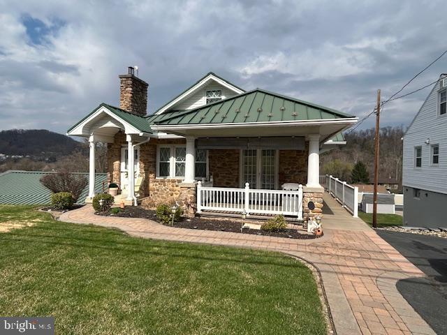 This immaculate Cape Cod house catches your eye with the beautiful local stone exterior and green metal roof, but it has much more to explore inside! The home has a large living room with stone fireplace and a large eat-in kitchen with updated cabinets. Open the French door to the front porch to bring some fresh air inside on spring days, or relax and on the covered porch.  The primary bedroom is on the main floor with two generous closets; the full bath next to it has a tub/shower combination and a linen closet. The main floor has central AC and forced air heat using a natural gas furnace. The second floor is a large loft area that can be used as a bedroom, media room, office or storage room. Below the main floor is a walk-out basement featuring a large laundry room and garage space for 4 cars! There is a workbench area, a wood burning furnace (currently not used), a 28' X 24" garage bay, a 28' x 13' garage bay and a 12' x 10' garage bay. All garages have working electric garage doors. Walk out from the basement to a beautiful 23' x 13' paver patio where there is plenty of room for a table and chairs or a swing to enjoy the outdoors. Two sheds are included on the 2 parcel property which totals .50 acres. The paved driveway allows you to drive from the main street to the lower level of house and exit through an alley. This property will be a delight to the next owner, don't wait to schedule your showing! Pre-approved Buyers Only Please!