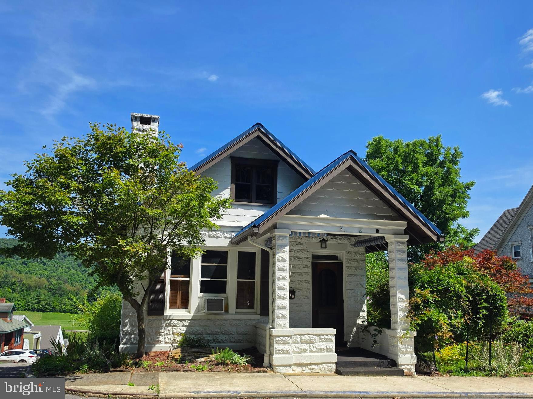 Nestled in the charming Mountainside neighborhood of Cumberland, Maryland, this classic home blends timeless character with modern convenience. Conveniently located near the local middle school, this inviting property is full of unique architectural details and endless potential.  The main level features a beautiful wooden pocket door leading into the spacious living room with a cozy fireplace, a formal dining room perfect for entertaining, two comfortable bedrooms, a full bath, and a nostalgic kitchen filled with vintage charm. Just off the kitchen, the rear porch provides the perfect spot to relax and enjoy restful evenings. The lower level offers a laundry area, ample storage, and an attached one-car garage. Outside, the inviting yard and established gardens are ready for your personal touch.  One of the home's most distinctive features is the walk-up attic, which leads to a rooftop deck showcasing breathtaking panoramic views of Historic Cumberland and the surrounding mountains.  If you're looking for a home with character, charm, and an opportunity to make it your own, this is one you won't want to miss. Schedule your private tour today!