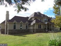 Pictures coming Monday- Tucked off the road and enveloped by almost 58 acres of serene woodlands, this extraordinary estate unfolds across two tax parcels, offering a sense of escape that's impossible to duplicate. A private approach sets the tone before the home even reveals itself; a 4,700 sq. ft. custom-built retreat where every detail was considered and every space designed to be lived in, not just admired. The home greets you with a grand foyer anchored by slate tile, and from there, hardwood floors carry you through a floor plan that balances elegance with unmistakable warmth. The kitchen stands as the heart of the home generous, sunlit, and anchored by a massive island, with an enormous butler's pantry ready to support everything from quiet family breakfasts to holiday feasts. The adjacent breakfast nook and formal dining room each offer their own personality, the latter centered around a wood-burning fireplace that makes every dinner feel like an occasion. Nearby, a bar room invites lingering conversation, while the living room, plumbed for a propane fireplace, awaits cozy evenings in. Tucked away for productivity is a private office, and the convenience of a first-floor laundry room, powder room, and a stunning main-level primary suite; complete with two walk-in closets and a spa-like bath with a soaking tub, separate shower, and water closet; makes single-level living effortless. Upstairs, the second floor feels like its own wing. A spacious suite with a private sitting room, two additional bedrooms, and a full bath create an ideal setup for guests, family, or anyone craving a little extra space to spread out. Beyond the walls of the home, the outdoor living is just as compelling. A covered patio stretches across the rear, complete with a fireplace and built-in speakers, setting the stage for everything from quiet morning coffee to lively evenings under the stars. The land itself is a quiet revelation; four fenced acres, a glassy pond, and miles of trails carved through the woods, offering daily invitations to wander, ride, or simply breathe. And then there's the barn. A striking four-stall structure with a circular staircase winding up to the hayloft, a full bathroom, an auxiliary unit, a feed room, and a tack room, it's been the backdrop for weddings and gatherings; a space with a story already written, and room for many more chapters to come. Two tax parcels. A two-car garage. Nearly 58 acres of privacy, beauty, and possibility. Properties like this don't come along often; and when they do, they don't last.