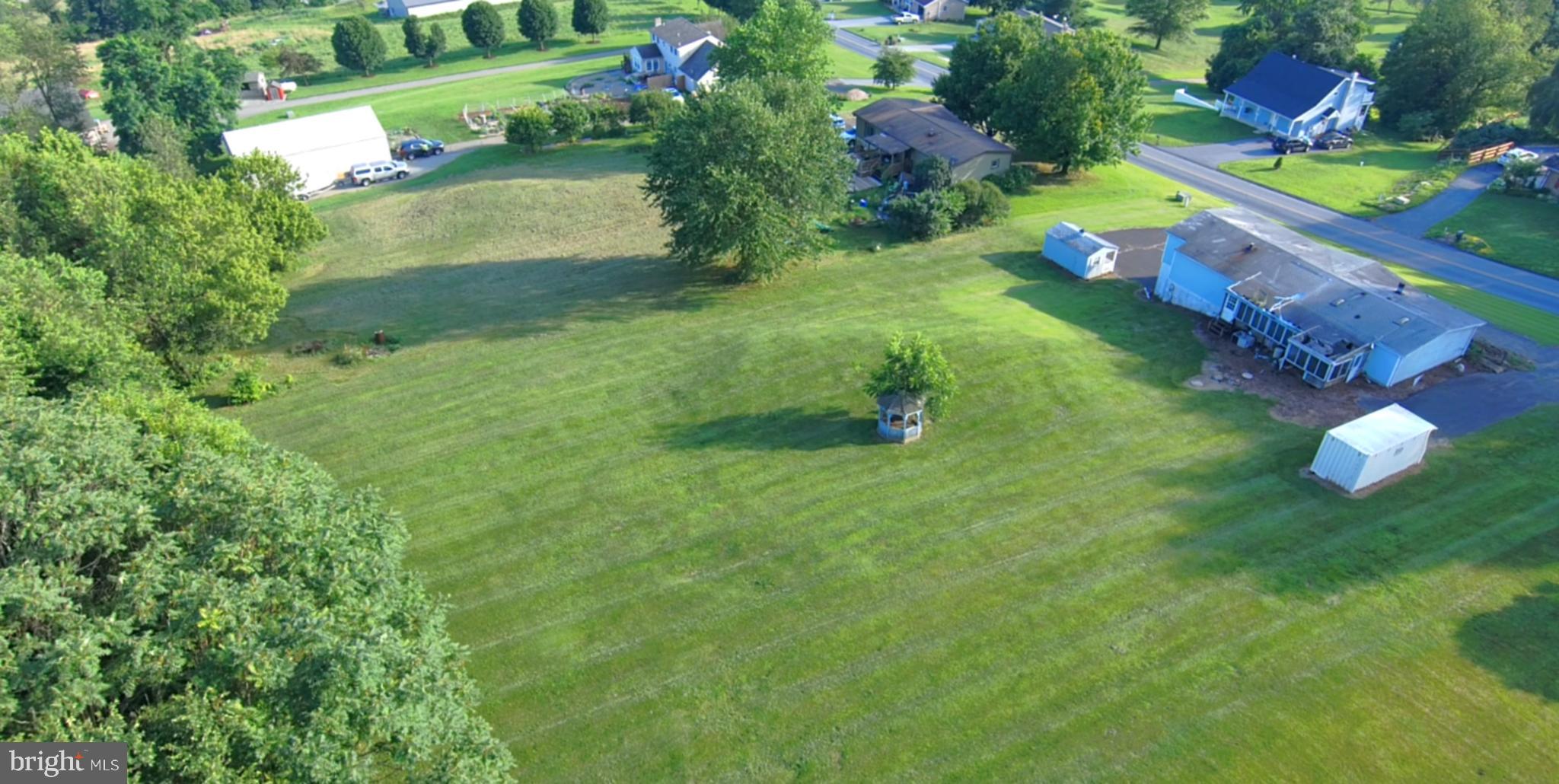 RARE opportunity to purchase an entire ACRE of CLEARED LAND on a STUNNING HILLSIDE in the country!!  This property is one of a kind with its hillside location, farmland views of the valley, and cleared landscape with a private tree-lined back border.   If you've been looking to exchange the hustle and bustle of city life for a peaceful, rural environment where you can watch horse and buggies drive by, this is the place!!  
This property features a double wide modular home which was placed on a concrete foundation back in 1987, when it was purchased new.  The foundation consisted of a finished basement plus a 2-car garage.  The home has been vacant for 20 years.  Possibilities  exist here to explore removing and replacing the modular home with a new one, or demo and build your dream home!  Any builder welcome!  
Prior to Covid, the seller had gone to great lengths of working with a local builder and had extensive planning done to build a 6,000sf home on the land.  Unfortunately, the post-Covid supply shortages caused prices to escalate  sky- high, so plans didn't come to fruition.  However, the seller is happy to share the plans from about 5 years ago, which will hopefully assist the next owner.  She worked with a land engineer and developed storm water management and septic system plans.  The property had been perc tested and approved for a sand mound system!!  While there is an existing well and septic, the township requires new systems be installed for both.  There is existing electric service.