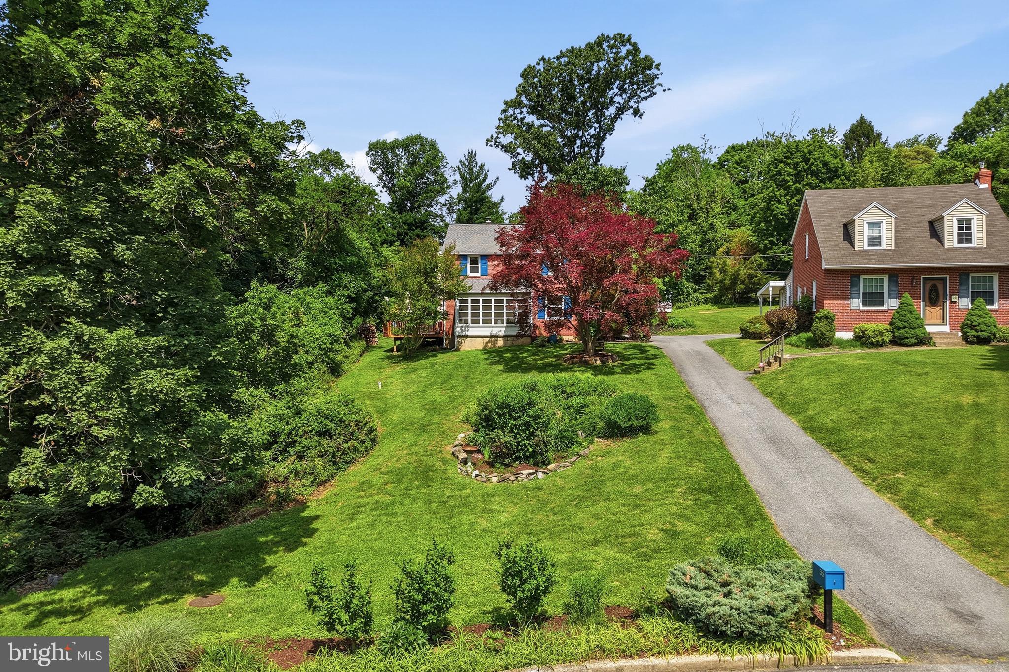 Elevated above the street on a private lot with a perfectly flat backyard, this exceptional Colonial offers the rare combination of privacy, space, and walkability, all within a secluded neighborhood just a short stroll from downtown Media's restaurants, cafés, shops, and community events.

Offering 4 bedrooms and 2.5 bathrooms, 53 Letitia Ln provides an impressive amount of parking and storage, including an attached one-car garage, carport, driveway parking, and a large detached two-car garage that is perfect for additional vehicles, storage, hobbies, or an elaborate workshop.

Over the years, this expanded Colonial has thoughtfully preserved its original charm while adding a spacious primary suite retreat. The suite features a generous private bathroom, two walk-in closets, a bay window sitting area, and, best of all, a large private deck overlooking the backyard. A spiral staircase conveniently connects the deck directly to the yard below.

Comfort and convenience are found throughout the home, with two separate air-conditioning systems, multiple entrances from the front, sides, and rear, and a roof that is only approximately six years old.

Outdoor living is a true highlight. In addition to the expansive, level backyard, ideal for games, gatherings, and entertaining, a side deck located just off the living room and near the kitchen provides the perfect everyday spot to relax, dine outdoors, or enjoy a morning cup of coffee.
The enclosed front porch has proven to be a favorite space for the current owners, serving as a practical transition area during the winter months while also providing an ideal place for their children to play, create, and work on projects.

Additional living and storage space can be found in the partial basement, which is partially finished while still leaving room for storage and utility needs.

If you have been searching for a spacious single-family home on a beautiful private lot, tucked away in a quiet neighborhood yet within walking distance of everything downtown Media has to offer, 53 Letitia Ln, which is part of the Rose-Tree Media School District, is one you truly need to experience in person.