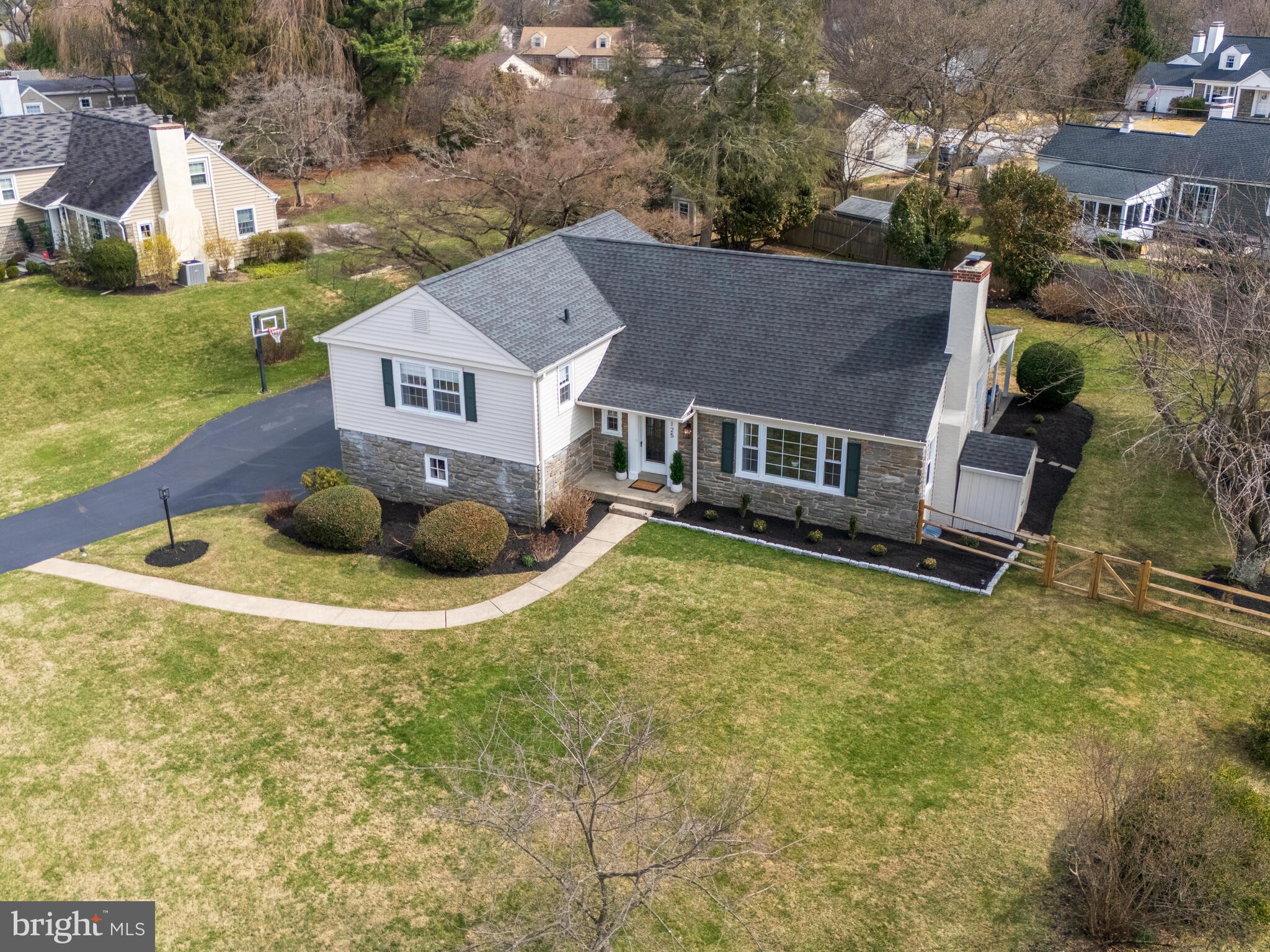 Welcome to 125 Clover Hill Lane in Wayne, Pennsylvania, a beautifully maintained split-level home offering space, flexibility, and a layout designed for the way you actually live. Tucked away on a quiet, non-through street, this home enjoys a peaceful setting while still being just a few blocks from everyday conveniences. From the moment you arrive, the stone-accented exterior, mature landscaping, and fenced rear yard create standout curb appeal. Inside, a welcoming foyer hallway sets the tone and draws you into the home’s bright, thoughtfully connected living spaces. To the right of the foyer, the living room is filled with natural light from a large front picture window and anchored by a wood burning fireplace, creating a warm and inviting space to unwind. Straight ahead, the heart of the home awaits: an updated kitchen featuring stainless steel appliances, tons of cabinet space, a peninsula with bar seating, and a beverage refrigerator, all opening seamlessly to the dining area. A rear door leads directly to the covered paver patio, making indoor-outdoor dining and entertaining effortless. A main-level powder room is thoughtfully positioned off the foyer for everyday convenience and guests - exactly where you want it. Upstairs, the home continues to impress with three well-sized bedrooms and a beautifully renovated full hallway bathroom. One bedroom functions as a primary suite with generous closet space and a private en-suite bath featuring a large, tiled walk-in shower. A few steps above, a fourth bedroom, or second primary suite, features built-in storage, ample closets and its own en-suite bathroom. Just a few steps down from the foyer, the lower-level den offers built-in shelving and cabinetry, access to the two-car garage, and another entry point to the backyard - ideal for flexible everyday living. Continue down to the finished basement, a versatile space ready for a workout area, media room, hobby space, or whatever suits your needs. The basement includes two storage closets and an unfinished section that houses the laundry and utilities with additional room for storage. The home’s layout offers the best of both worlds with open, connected spaces when you want to gather, and distinct levels that provide privacy when needed making every area feel intentional. Out back, the fenced-in yard and expansive paver patio provide a great setting for relaxing or entertaining, while a 10’x20’ shed keeps outdoor essentials neatly organized. Located in the highly regarded Tredyffrin-Easttown School District, this home offers easy access to Strafford Park, McKaig Nature Trail, Chester Valley Trail, local swim clubs, golf courses, shopping, dining, bars, and regional rail. With convenient access to major routes including BUS 30, 202, and the PA Turnpike, commuting is simple. 125 Clover Hill Lane delivers the space, layout, and location you are searching for - move-in ready and waiting for the next chapter. Don’t miss out on this one-of-a-kind Main Line home! Schedule your showing today!
