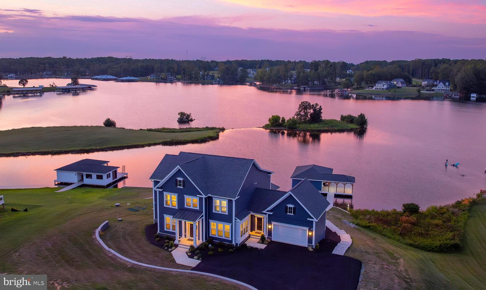 Presenting 457 Rock Island Ridge, a true homage to waterfront luxury at Lake Anna.  Framed by sweeping 180-degree water views that stretch across the private side of Lake Anna, this furnished opulent masterpiece constructed in 2023 is set on a gentle 1.1 acre lot, showcasing 220 feet of pristine shoreline that is protected by bulkhead, a sandy beach encased by the finest hardscaping, large private boathouse, and sunsets that will ingrain memories for life.  Thoughtfully designed for both elegance and comfort, this waterfront craftsman offers over 6,000 square feet of spacious living space, and delivers an unmatched blend of sophistication and lakeside leisure. Six expansive bedrooms - including a first floor bedroom suite - and seven beautifully appointed bathrooms amount to lavish accommodations.  Each space has been crafted with generous proportions and refined details, from the tray-ceilings in the primary suite with spa-inspired finishes, including stand-alone tub, walk-in tiled shower and double vanity, and 10-foot ceilings on the main level to guest suites that feel like private retreats to themselves. The home’s interiors radiate opulence—an exquisite gourmet kitchen with quartz countertops, an island with pendant lighting and stainless appliances, a butler’s pantry with coffee bar, integrated Sonos sound system, designer furniture and lighting, elegant coffered ceilings in the living room, water softener system, and walls of glass showcasing the lake.  The home also features a massive finished basement with movie theater area, a state-of-the-art gym with an $8,000 LifeFitness treadmill, dumbbells and other gym equipment, high-end ping pong table, shuffleboard game, air hockey table, and beverage refrigerator. Outside, unwind within a seamless extension of living space on your expansive composite deck overlooking the lake, a large screened-in porch, custom exterior lighting package, sandy beach, and a massive hard-scaped patio that leads down to your shoreline and boathouse.  An exquisite, turn-key opportunity with designer furniture, meticulous decorations, abundant home furnishings, and high-speed fiber internet wired throughout the home with CAT6 cable, this unparalleled lake house is equally suited as a luxurious vacation retreat or an exceptional investment property.  INVESTORS: short term rentals are permitted here in Rock Island Landing.  With its size, amenities, layout, and prime waterfront setting, this home offers the rare opportunity to generate significant rental income, while enjoying the ultimate lakefront lifestyle.  Excellent location, just minutes to groceries, numerous restaurants, nail salon, vet clinic, The Lake Anna Taphouse, Coffee & Creamery, and more.