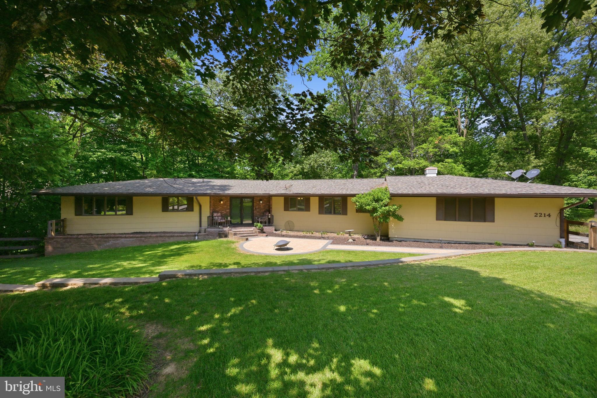 Tucked into a picturesque setting in the heart of Catonsville, this sprawling ranch-style home at 2214 Arapahoe offers exceptional space, versatility, and timeless comfort. Lush landscaping and inviting hardscape create stunning curb appeal, while the side-load two-car garage and expansive layout set the tone for easy everyday living.

Inside, the open-concept floorplan is filled with natural light and thoughtfully designed spaces, including a spacious great room, sun room overlooking the park-like backyard, craft room, laundry room, and convenient main-level powder room. The updated kitchen is beautifully appointed with rich wood cabinetry, granite countertops, stainless steel appliances, and generous prep and gathering space perfect for entertaining.

The main-level primary suite provides a private retreat with an updated bath, while two additional bedrooms and a full hall bath complete the main level. Step outside to the deck and enjoy peaceful backyard views surrounded by mature greenery.

The fully finished walk-out lower level offers incredible flexibility with a full in-law kitchen, expansive family room, three additional bedrooms, a full bath, abundant storage, and sun-filled spaces with full-size windows and direct backyard access — ideal for multi-generational living, guest accommodations, recreation, home office use, or extended entertaining.

Perfectly positioned just minutes from the shops, dining, and historic charm of Ellicott City and Catonsville, this home also offers convenient commuter access to I-695 and nearby outdoor recreation along the Trolley Trail. A rare opportunity to enjoy spacious single-level living with exceptional flexibility in one of the area’s most desirable locations.