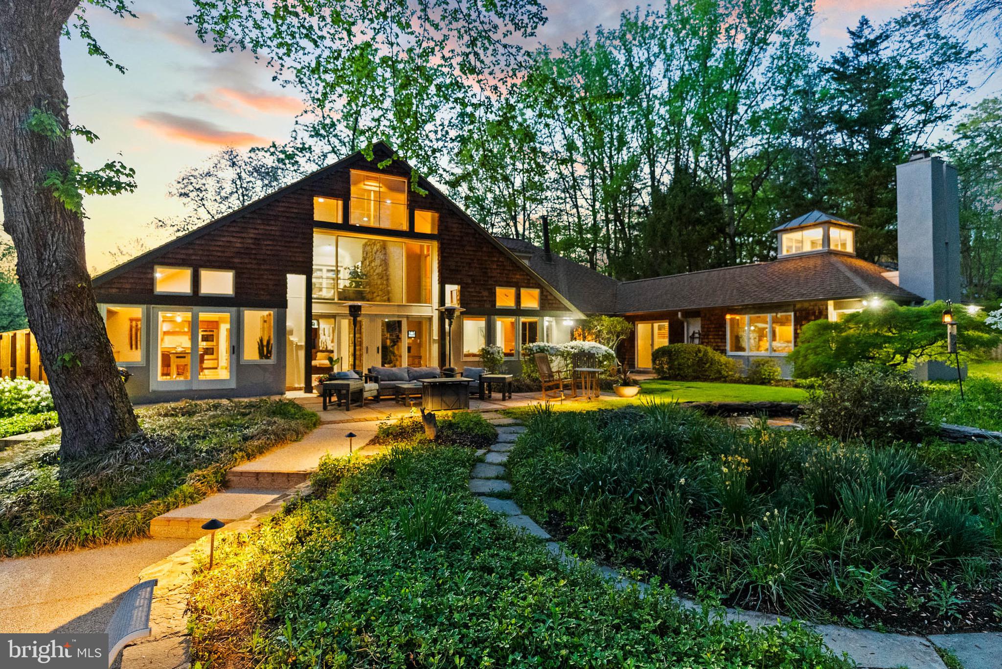 This stunning Crowell-Baker custom contemporary is a rare find, thoughtfully reimagined by renowned architect Mark McInturff and meticulously updated throughout by the current owner with over $200K in enhancements. Nestled on a serene and beautifully landscaped 2-acre lot, this home offers the best of one-level living, with timeless architectural features and today’s most coveted smart-home upgrades.
A welcoming stone-floored foyer opens to a graceful layout that includes three bedrooms in one wing and a private library with fireplace and built-ins adjoining the tranquil primary suite in the other. The suite features dual walk-in closets, a spa-inspired bath, a cozy fireplace, and smart home enhancements such as Lutron Caseta lighting, motion-sensor switches, and a smart thermostat.
The main level showcases an expansive living room with a sitting area and fireplace, formal dining room with designer lighting, and a sun-drenched morning room with refinished natural white oak floors. The updated kitchen features refinished cabinetry, new hardware, premium appliances (including a refrigerator with separate ice ball maker), and seamless access to the reimagined mudroom with smart locks and commercial-grade garage flooring.
Entertain in style in the oversized family room with fireplace, built-in bourbon bar, and sliders that now match the custom front door. The open loft above offers additional flexible space, while the partially finished lower level includes a spacious rec room with fireplace and wet bar, a bedroom and full bath, and ample storage. A new epoxy floor, dry-fall ceiling, and LED flat panel lighting add a sleek finish to the basement.
Outdoors, the transformation continues with whitewashed brick, fresh paint on all wood trim and stucco, updated fencing and gates, a new paver walkway, and smart Lutron-controlled landscape lighting. Relax by the fire pit, unwind on one of the multiple stone terraces, or enjoy the in-ground pool, serviced weekly through August 2025 and equipped with a new Polaris pump.
Additional highlights include upgraded bathrooms throughout, premium carpeting, custom vent covers, designer fixtures, extensive smart lighting, floodlight security cameras.
This is a home where architectural pedigree meets contemporary sophistication—offering not only comfort and style, but also peace of mind with thoughtful updates at every turn. Public water & Sewer
