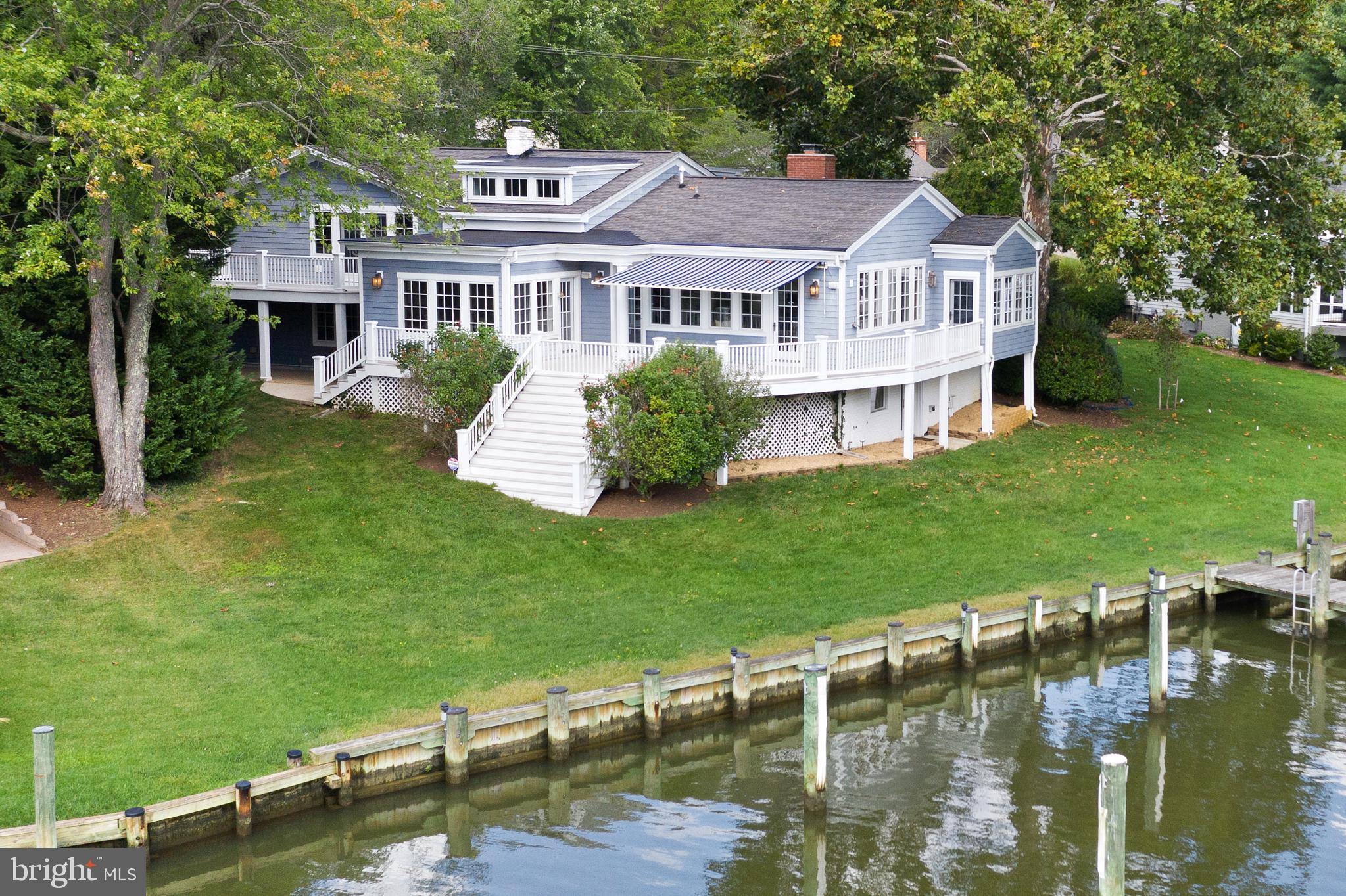 Let's talk water!
Amazing waterfront on Little Aberdeen Creek*   7+ ft Protected  MLW with  gorgeous straight down the creek  views to the South River* Slips that  accommodate a large motor or sail boat with additional room at the pier to configure additional slips or boat lift. 

This Coastal style home with it's welcoming front porch has Lovely curb appeal but does not prepare you for what you see when you walk in.    The views take your breath away.  There is a  gorgeous vaulted and  light filled  great room which offers floor to ceiling windows and doors that focus  on and amplify  the sweeping views down the creek.  Beautiful light cherry built in cabinetry is carried throughout the  great room and warms the gourmet kitchen and breakfast nook. These rooms all access  a large  deck for entertaining  on the water.  Tucked off the rear corner of the house is  a pretty sunroom with french doors that  look out to the pier and  makes  a great office, reading or music room.  A few steps down from the kitchen is a walk-out  lower level  with a  cozy den,  2nd wood burning fireplace, adjoining guest bedroom, bath and laundry.  One additional  level down is the recently renovated recreation room with plenty of room for kids  to play  as well as a  new  steam shower bath that is is a great addition when returning  from a day on the water. This level has walk-out access to the newer pier.  The upper level offers a master bedroom  suite opening to a private  morning deck, two other large bedrooms and a full bath.   The community of Wild Rose Shores  is only minutes to Historic Annapolis, and the Eastport Maritime District.  It is an easy commute to both  DC and Baltimore.  Your family and friends will love to visit!