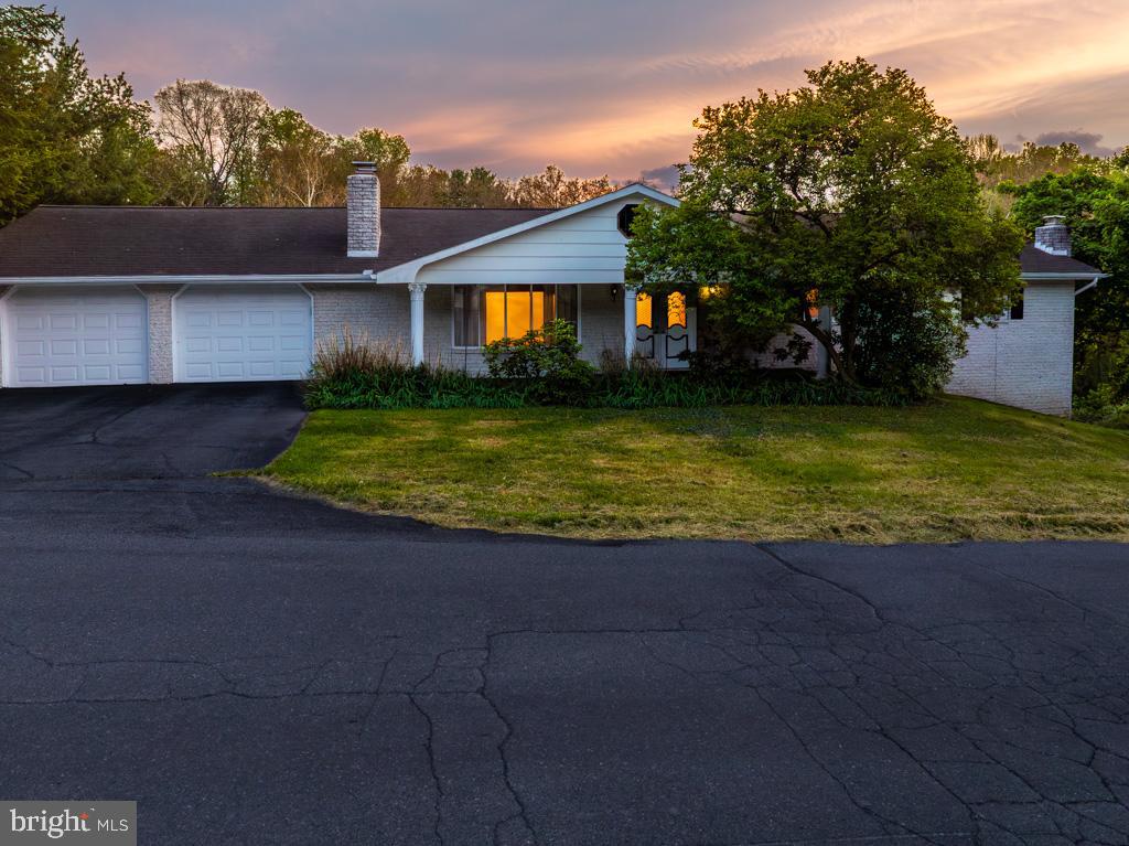 REDUCED $10,000! LOOKING FOR THE SPECIAL BUYER!!   Welcome home to a charming white split-rock rancher set on 2  lots, 26 & 26 A,  a total of .53 acres on a corner lot - with minimum restrictions — a rare find that gives you the freedom to truly make the property your own. With over 1,800 sq. ft. of main-level living, this home offers 3 generous bedrooms and 2 full baths, including a comfortable primary suite with its own private bath.  A convenient half bath is located on the lower level.
Step inside through the tiled foyer, and you’ll immediately notice how well cared for this home is. Beautiful hardwood floors flow through the living and dining room and down the hallway, creating a warm, cohesive feel. Recent updates within the last three years — including fresh interior paint, new carpet, a new oil tank, and a new dishwasher (2026) — mean you can move right in and enjoy.
The kitchen is both functional and inviting, featuring solid-wood cabinetry, a center island with a butcher-block top, and two lighted double-door pantries for ample storage. Three fireplaces throughout the home add charm and cozy gathering spaces for every season.
A striking spiral staircase leads to an additional 1800 square foot finished space to include a walk-out Recreation Room— a true extension of your living space. Here you’ll find an office with built-in bookshelves and an electric fireplace, a recreation room with a wood-stove insert, a side area room with a full-size commercial pool table that conveys, and an additional area already wired for surround sound, ready to be connected. This level also includes a Solarium glass-enclosed room to maximize sunlight. A laundry room with a half bath, and an oversized 23x28 unfinished storage area under the garage.
Outdoor living is just as enjoyable. Relax on the covered front porch or unwind on the 10x24 rear deck with Trex flooring and vinyl railings. The gently sloping backyard leads to a peaceful, wet stream along the property’s edge, offering a serene, natural backdrop.
An oversized 23x29 front entry two-car garage provides plenty of room for vehicles, hobbies, or storage.
All of this is conveniently located near Rt. 45 with easy access to Martinsburg, Shepherdstown, and Rt. 11, and a variety of local restaurants and shopping.