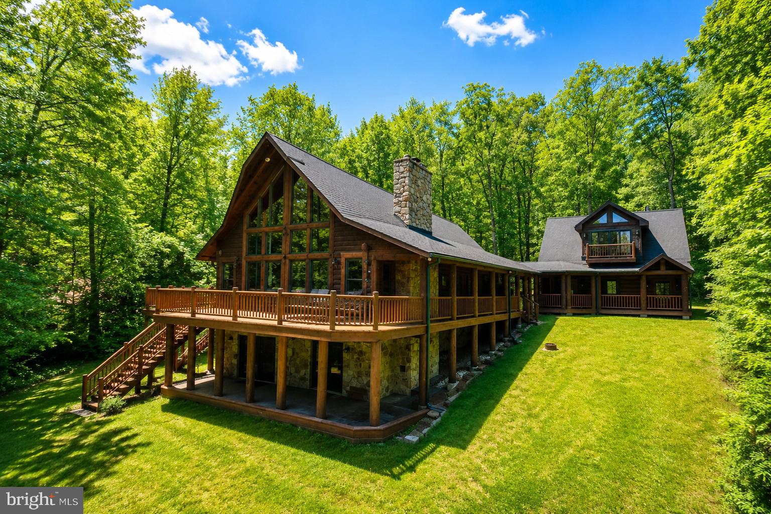 This luxurious log home retreat within the prestigious Thousand Acres Lakefront & Golf Community takes the Deep Creek mountain-lake lifestyle to an entirely new level. Designed with entertaining and multi-generational living in mind, the home offers a gracious and spacious floor plan with exceptional craftsmanship and timeless rustic elegance throughout. A dramatic wall of glass frames stunning lake views and fills the home with natural light, seamlessly blending indoor and outdoor living. The thoughtfully designed layout features an extraordinary kitchen, oversized mudroom for all seasons of recreation, four private primary suites, and two massive stone wood-burning fireplaces. Additional living space above the oversized garage—currently used as a fifth bedroom with full bath—adds even more flexibility for guests and gatherings. An exceptional opportunity to own a truly remarkable home in one of Deep Creek Lake’s most coveted communities.