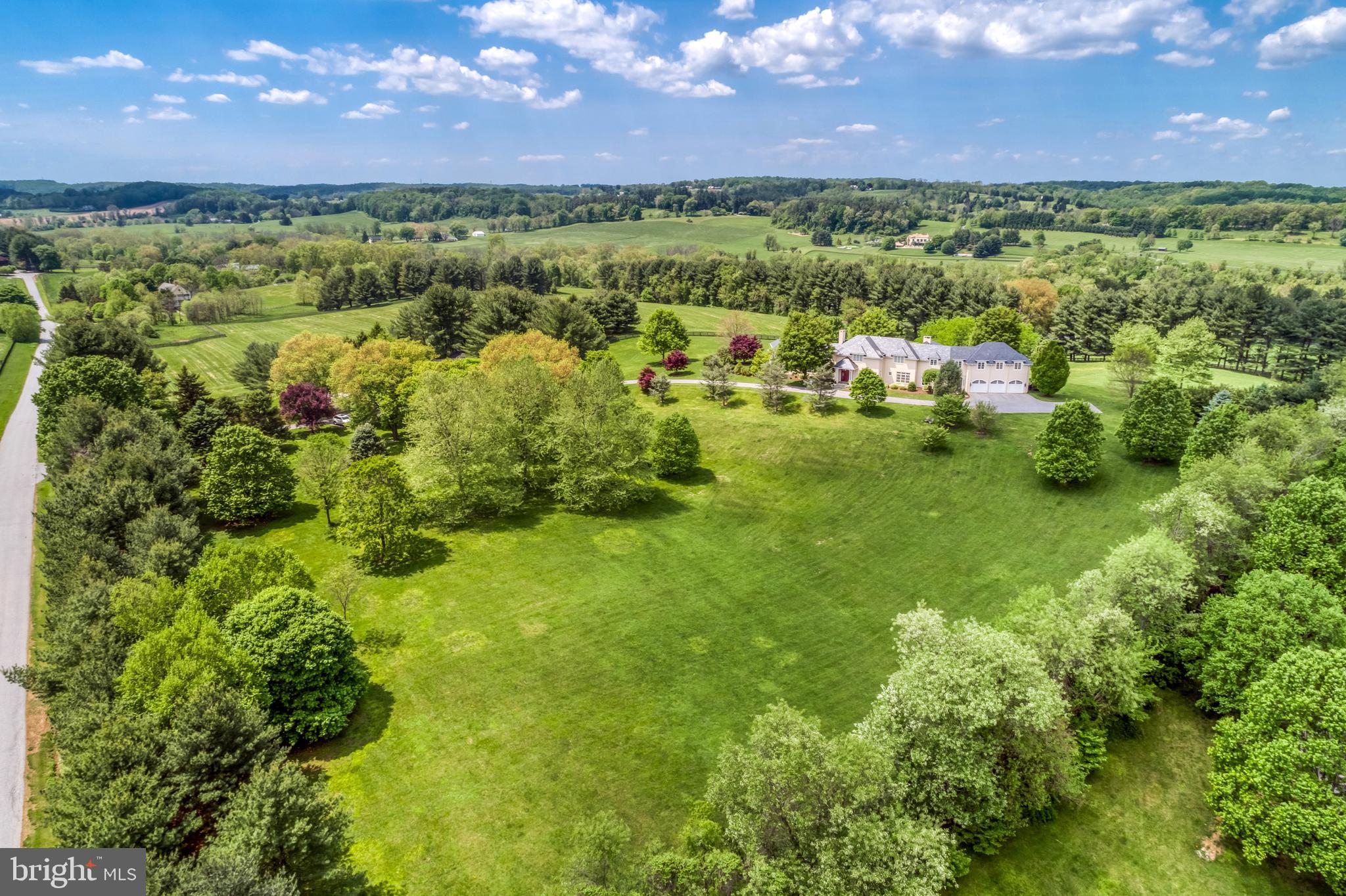See RESIDENTIAL LISTING  MDBC488874 for additional photos and details. Inspired by English country architecture and situated in the heart of Maryland hunt country this warm and inviting home offers extraordinary panoramic vistas and remarkable pastoral views from every window. The elegant center hall with mahogany door and curved staircase is flanked by understated light-filled formal rooms and sophisticated casual spaces with high ceilings, quarter-sawn random plank oak hardwood flooring, and exquisite millwork throughout. The handsome gourmet kitchen features premium appliances, 6-burner gas range with griddle, expansive island, breakfast room, walk-in pantry, formal butlers pantry, and a mahogany writers desk facing long views of countryside. Highlights of the great room include the soaring cathedral ceiling with exposed beams, built-ins with entertainment center, and a magnificent floor-to-ceiling stacked stone wood burning fireplace extending to covered terrace with outdoor stone fireplace. The spacious main level master bedroom suite opens to second covered blue stone terrace for quiet respite. A finished basement offers second family room with wood burning fireplace, game room, fitness room, and full bath. Country-sized mud room for pets and lacrosse sticks. 8-stall stable includes office and dressage barn or second garage. Perennial gardens and gently manicured rolling lawn merge into pastureland and woodlands with riding trails providing diverse habitats for a multitude of native plants and animals. Nature abounds - witness bald eagles, red-tailed hawks, kingfishers, blue herons in flight. Enjoy the cacophony of peepers in near-by ponds on warm summer evenings, and seasons defined by wildlife who make the valley their home. Outdoor enthusiasts are drawn to the area known for steeplechase and equestrian events, horseback riding, biking, hiking, hunting, sporting clays and fly-fishing. Neighbors are committed to conservation and take pride in protecting open space and the rural and agricultural character of this renowned region. A unique and breathtaking property in a coveted and private location.