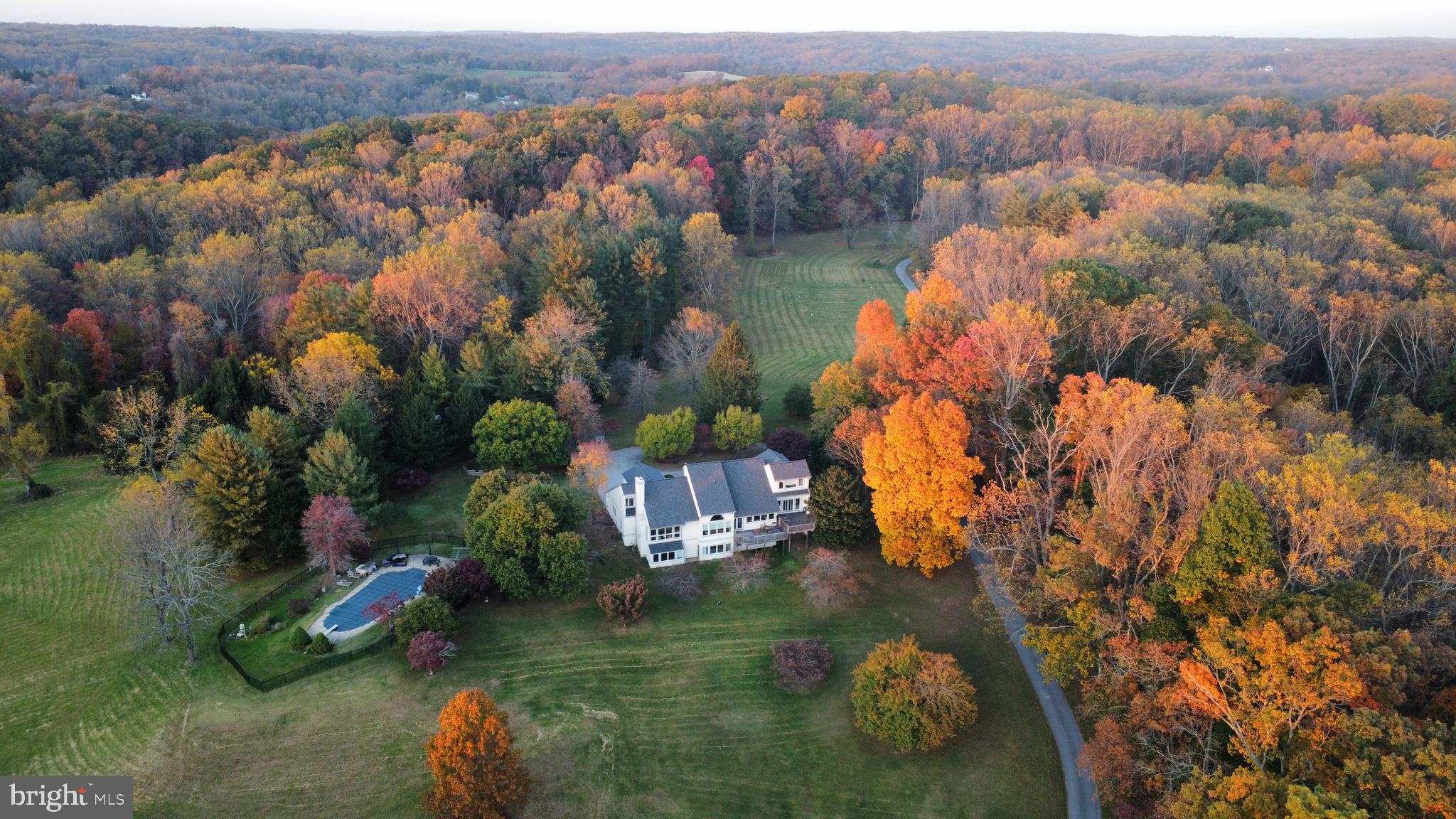 Exceptional Properties. Exceptional Clients. Presenting 15701 Home Rd — “Turtle Hill” — an extraordinarily rare opportunity to own 33 breathtaking acres in Sparks, ideally positioned just moments from the Big Gunpowder Falls and NCR Trail. A long, private approach sets the tone as you arrive, revealing a one-of-a-kind contemporary residence perched atop Turtle Hill. Rolling pastures, open fields, and mature Mid-Atlantic forest surround the home, offering truly spectacular 360-degree views. Inside, a grand foyer welcomes you with soaring ceilings and an abundance of natural light. Expansive windows frame the landscape from every angle, while the main living level showcases an open-concept kitchen, dining, and family room designed to capture the sweeping vistas below. Elevated corridor-style hallways create an airy, architectural feel and connect the upper levels with striking visual continuity. The upper levels feature five bedrooms and three full baths, including an exceptional top-level primary suite complete with vaulted ceilings, exposed beams, a dressing area, dual-sink vanity, soaking tub, and walk-in shower. The lower levels offer additional flexible living space, including a spacious recreation/family room with wood-burning fireplace, a private guest suite with full bath, and a large bonus room ideal for a home office, gym, or playroom. Constructed with concrete commercial-grade materials, this residence is as solid as it is distinctive, complemented by an oversized 2+ car garage. Outdoors, your private retreat awaits—featuring an in-ground pool, metal barn, and endless opportunities for recreation. Whether it’s hunting, ATV riding, or simply enjoying the serenity of nature, Turtle Hill delivers a lifestyle that is truly unmatched.