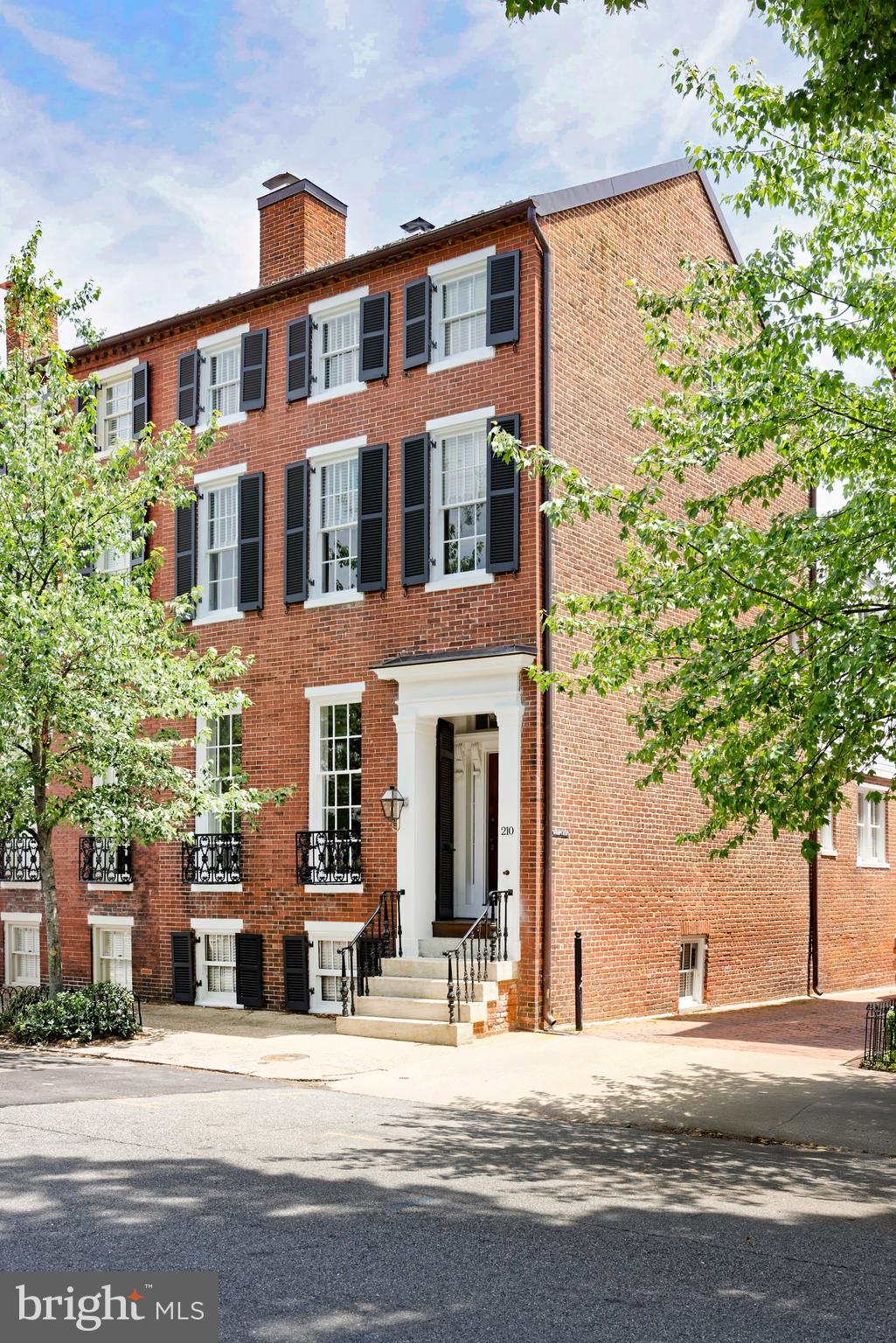 A rare offering in the heart of Old Town, this distinguished circa-1820 semi-detached home combines timeless architectural details with thoughtful renovations that honor its historic character.  Lovingly maintained by only three owners since the 1940s, the residence has been carefully preserved and enhanced over the years, showcasing remarkable original features and exceptional craftsmanship.  Highlights include gleaming hardwood floors, elegant moldings, soaring ceilings, and a wood-burning fireplace with a classic brick hearth and mantel.

Beyond the swing door and transom window, the chef’s kitchen boasts custom tall cabinetry, marble countertops, premium appliances, and a wet bar with glass-front cabinetry.  Exposed wooden beams add warmth and texture, while bar seating creates an inviting space for casual dining and entertaining.  A door from the kitchen provides direct access to a small Trex landing leading to the private patio.  A conveniently located powder room completes this level.  

Relax in the primary suite, a serene three-window-wide retreat featuring rich hardwood floors, custom built-in bookshelves, and a spacious walk-in closet. The spa-like marble bath offers a large seamless glass shower and refined marble accents, creating a calm setting.  The light-filled second bedroom on this level is ensuite and includes hardwood floors, abundant natural light, and distinctive bell jar light fixtures. Its renovated bath features a beautiful mosaic marble floor and a tub/shower combination.  A generous laundry room provides additional storage and everyday convenience.  The upper level offers two spacious bedrooms with neutral carpeting and ceiling fans, ideal for family or guests, along with a full bath.  The lower level offers a flexible space, currently used as a workout area, featuring vinyl flooring, two windows, and additional storage.

Enjoy outdoor living on the flagstone patio, surrounded by mature landscaping including a Japanese maple tree and other greenery.  The space is fully fenced and offers outdoor lighting, a small shed, and extensive under-deck storage.  One year of prepaid parking for one vehicle at the Alexandrian Hotel is included.  Ideally located in the coveted southeast quadrant of Old Town, the home offers easy access to wonderful shops, restaurants, parks, the river, public transportation, and the Mount Vernon trail.