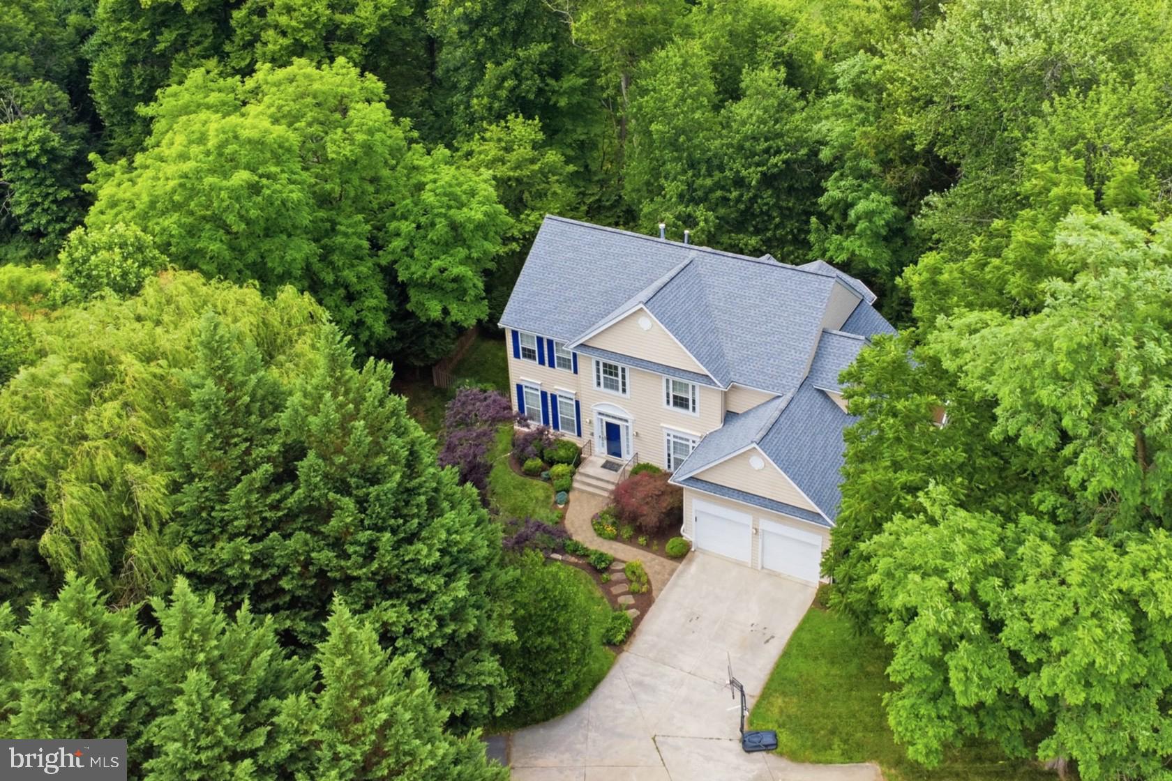 Welcome to 4647 Yorkshire Drive, a stunning home nestled on a quiet cul-de-sac in Brampton Hills, one of Ellicott City’s most prestigious and sought-after communities. Spanning over 4,700 square feet, this exquisite home delivers an exceptional blend of comfort, style, and functionality, all perfectly situated against a tranquil backdrop of tree-lined open space. Offering total peace of mind for the foreseeable future, all critical systems have been recently modernized, featuring an updated upper HVAC (2021) and lower HVAC (2020), water heater (2023), architectural shingle roof (2021), and a pristine 2025 refrigerator. Step into elegance with this breathtaking, two-story foyer that immediately sets the tone for the rest of the home. The dramatic high ceilings and gleaming hardwood floors create an incredibly airy and open atmosphere, allowing light to cascade down from the upper level onto a sweeping, open-concept staircase that serves as the focal point of the space. Establishing a seamless flow, the foyer opens into a living room boasting classic crown molding. The inviting dining room situated just off the living room provides a cozy retreat, beautifully appointed with crown molding, rich hardwood flooring, and large dual windows that bathe the space in natural light. The heart of the home features an open-concept kitchen appointed with gleaming granite countertops, sleek stainless steel appliances, pantry, and modern 42-inch cherry cabinetry. A peninsula with bar seating seamlessly connects the kitchen to a bright breakfast area, flowing naturally into a peaceful sunroom and a cozy family room centered around a warm gas fireplace. Flooded with natural light, these inviting living spaces showcase serene wooded views and overlook a sizable maintenance free deck. Completing this exceptional main level is a spacious private office featuring large, bright windows, a bonus room enclosed with  French doors with direct deck access, alongside a convenient half bath and a dedicated laundry/mudroom. Ascend to the upper level, where you will find four generously sized bedrooms, each thoughtfully designed with its own walk-in closet. The expansive primary suite serves as a luxurious private retreat, boasting soaring cathedral ceilings, a charming bay window, and dual walk-in closets outfitted with custom built-ins. Unwind in the attached spa-like bathroom, complete with a relaxing jetted tub, an oversized shower, and dual vanities. Rounding out the upper level is a beautiful hall bathroom, featuring sleek custom countertops and dual vanities to perfectly accommodate family or guests. The fully finished, walk-out lower level offers an abundance of space for relaxing and entertaining, designed so well that it could easily double as a private in-law or guest suite. At the heart of this level is a sprawling recreation room, fully equipped with a premium Bose surround sound system and anchored by a striking three-sided gas fireplace. Entertaining is a breeze with the expansive wet bar, complete with a built-in refrigerator and ample custom cabinetry. This level also features a large, private bedroom and a luxurious full bathroom boasting a spa-like steam shower. Step outside through the walk-out exit to enjoy a tranquil covered patio, offering the perfect vantage point to take in the beautiful, private wooded views. The home features a sprawling, maintenance-free deck equipped with convenient dual staircases that provide seamless, elegant access to the grounds below. Overlooking a spacious, fenced-in yard, this impressive outdoor entertaining area is perfectly framed by vibrant, lush greenery and mature landscaping. It offers a serene and picturesque setting that is equally suited for hosting large summer gatherings or simply unwinding in tranquility. Rounding out the property is a spacious two-car garage equipped with a dedicated Tesla charger for effortless home EV charging.