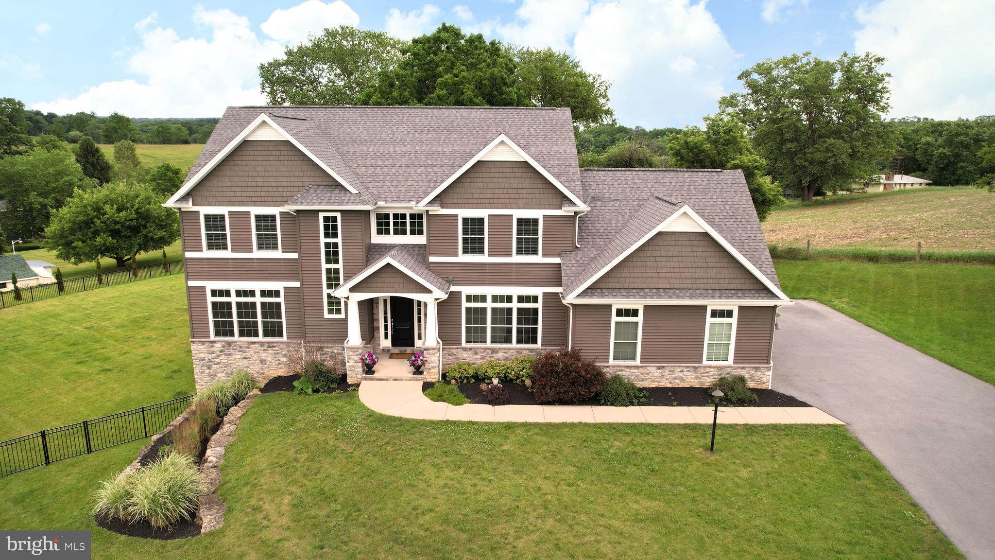 Elegantly designed and meticulously maintained, this stunning residence blends modern sophistication with timeless traditional touches in highly sought-after Stearns Crossing. Privately nestled off Mountain Laurel Road, a winding driveway welcomes you home while offering a peaceful sense of seclusion and retreat from the everyday. Thoughtfully crafted for both everyday living and effortless entertaining, the home welcomes you with an open-concept floor plan, soaring ceilings in the great room boasting a 2-story, stone fireplace, and 9-foot ceilings throughout the main level. At the heart of the home, the beautifully appointed white kitchen features an expansive center island, granite countertops, stainless steel appliances, an induction cooktop, and strikingly refinished hardwood floors. The adjoining morning room boasts ample natural light and a seamless transition to the rear screened-in porch overlooking a fenced in backyard and neighboring farm fields. The main-floor owner’s suite offers a peaceful retreat with a spacious walk-in closet and a spa-inspired bath featuring a tiled shower, soaking tub, and double vanity. An office, half bathroom, and impressive laundry/mudroom with a walk-in pantry round out the first floor. Upstairs, you’ll find four generously sized bedrooms, two additional full bathrooms, and a walkway with wrought-iron railings overlooking the stunning living space below. The lower level extends the home’s versatility with another bedroom, full bathroom, and an expansive family room with a walk-out to the covered patio and backyard. This exceptional home combines elegance, comfort, and functionality in one remarkable package. Conveniently located less than 10 minutes to downtown State College + Penn State campus.