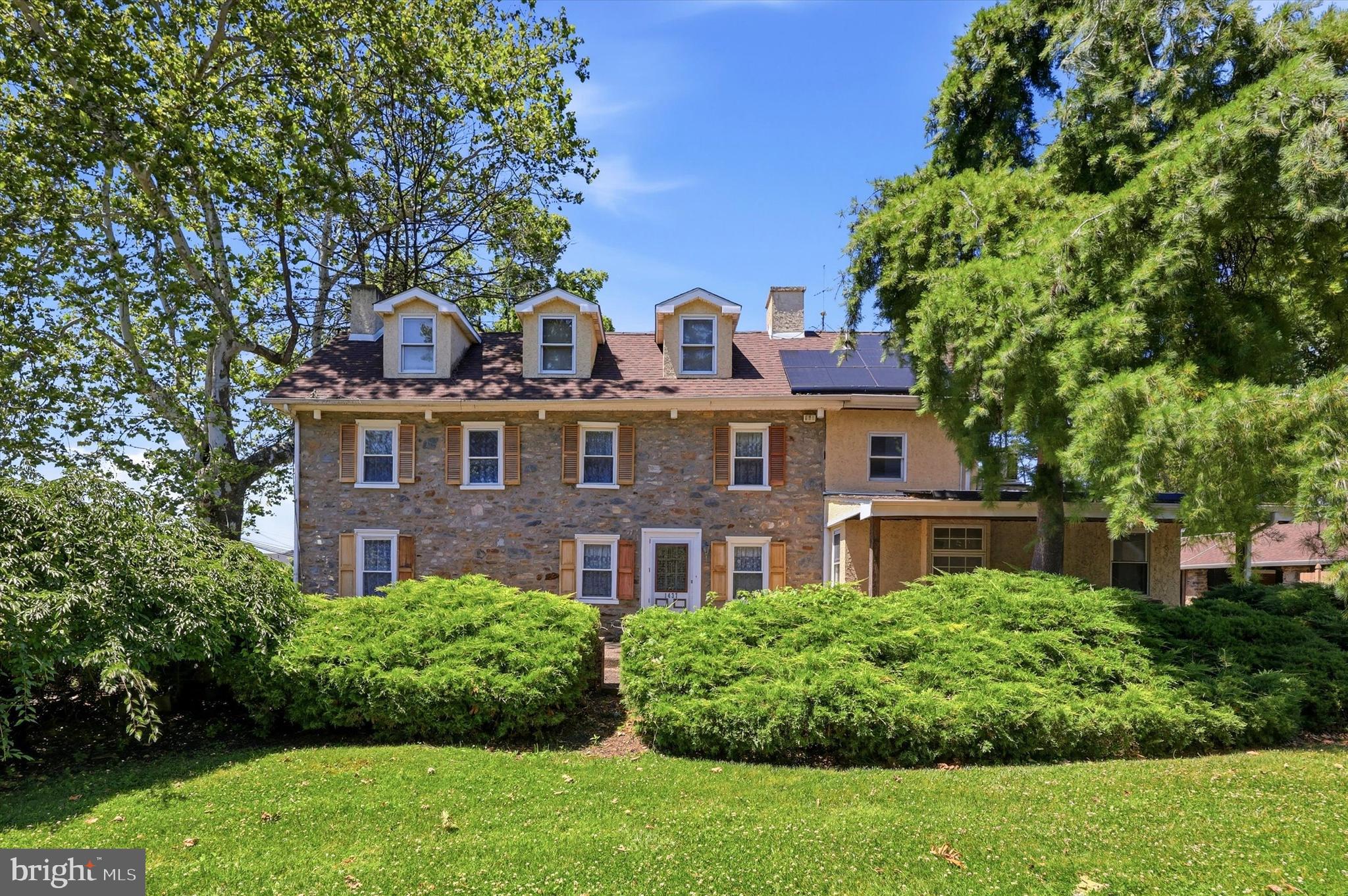 Nestled along the landscape connecting Bryn Athyn and Lower Moreland, 1437 Byberry Road stands as a surviving example of early Pennsylvania farm architecture. Believed to have been constructed in the early 1700s, this 18th-century fieldstone farmhouse reflects the craftsmanship and rural character of the region’s earliest settlers. Its thick stone walls, hand-hewn beams, and traditional layout speak to a time when homes were built with both practicality and permanence in mind.

The property was once part of a much larger tract of fertile farmland that supported orchards, vineyards, and mixed agriculture, a pattern deeply rooted in the agrarian history of Lower Moreland and the surrounding Bryn Athyn area. Early accounts of life on nearby farms, including those referenced in regional historical writings, describe a landscape of rolling fields, fruit trees, and working homesteads that formed the backbone of the community’s economy and culture.

For over 40 years, the home has been lovingly cared for by its current residents, who approached every renovation with a deep respect for the property’s heritage. Their work focused on exposing the natural beauty of the original stone and timber, preserving historic character while thoughtfully integrating modern comforts. The result is a home that feels both timeless and welcoming.  A place where centuries-old craftsmanship meets contemporary living in a way that honors the past without sacrificing convenience.

The property is accessed by way of a horseshoe driveway that wraps around the back of the main house (the left driveway from the curb is private and the right side is shared with houses located behind), allowing easy access in and out. As you step into the home off the back door, you’ll find a large family room area with exposed stone walls and loads of natural light – this space was formerly used as a home office. This room leads to the large and expanded eat-in country kitchen with an oversized island, plenty of cabinet space, and a powder room.

Towards the front of the house is the original structure, and here you will find a fireplace in the dining room and living room, both with gas log sets which heat this entire section of the home. On the second floor are two bedrooms, a full bathroom with soaking tub and stall shower, and laundry room. The third floor features a third bedroom and walk-in attic space for storage.

In the late 19th century, a carriage house was added to the property. This structure, too, was built with the same attention to durability and function, complementing the original farmhouse. Today, it consists of several garage and storage bays at its ground level and on the second floor is a 2 bedroom 1 bathroom apartment with a fireplace in the living room, vaulted ceilings, and a deck that overlooks the fenced-in back yard pool area.

Out back you’ll find your own summer oasis in the fenced in backyard area which has a heated in-ground pool and hot tub.

Just down the road you’ll find access to the Pennypack Rail Trail which provides miles of shaded gravel trail for biking, running or walking through nature, and a short distance from that is Upper Moreland’s Mason Mill Park.

For those who value authenticity, heritage, and the quiet dignity of a home that has stood for more than three centuries, this property offers something truly exceptional. Come visit 1437 Byberry Road, find your way home, and begin to write the story of this beautiful property’s next chapter.