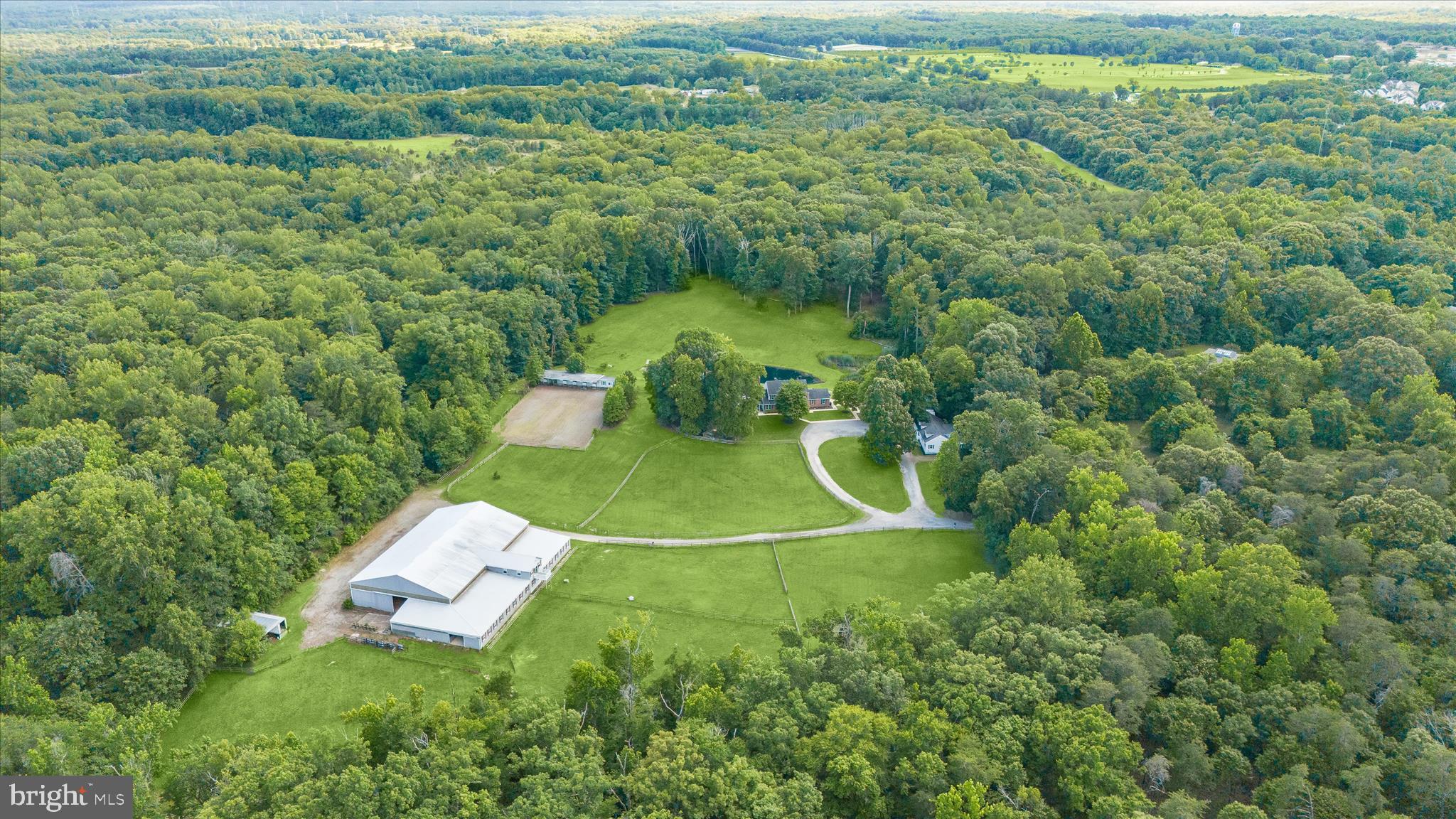 This exceptional 10-acre equestrian estate backs directly to the Cheltenham Wildlife Management Area, offering a rare combination of luxury living, premier equestrian facilities, and direct access to miles of scenic riding trails and outdoor recreation. The property features a beautifully updated main residence, a separate guest house, expansive equestrian amenities, a tranquil pond, and exceptional indoor and outdoor entertaining spaces.

The beautiful main residence offers 6 bedrooms and 4.5 baths. A private main-level primary suite with its own entrance is ideal for guests or multigenerational living. Thoughtfully renovated throughout, the home showcases new flooring and a reimagined gourmet kitchen featuring updated cabinetry, countertops, and appliances, complemented by designer lighting, a farmhouse sink, three ovens, and an impressive 8-burner range. Completing the kitchen is a spacious walk-in pantry designed to keep everything organized and within reach. The upper level offers generously sized bedrooms, a second primary suite, and a large laundry room. The fully finished lower level with a walkout expands the living experience with a fitness room, bedroom, full bath, and recreation area. 

Complementing the main residence is a separate 2-bedroom, 2-bath guest house with its own private yard, ideal for extended family, caretakers, or guests. Outdoor living is equally impressive, highlighted by a large enclosed entertaining pavilion with a fireplace and projector screen. From the pavilion, enjoy the peaceful sounds of the fountain in the private stocked pond, complete with its own boathouse and surrounded by natural beauty.

Designed for the serious equestrian, the impressive center aisle barn features 18 stalls, an attached indoor arena, and a beautifully renovated lounge, complete with a full bath, a half bath, and viewing areas. Two tack rooms, a feed room, a wash stall with hot water, and a laundry hookup make this facility fully functional for boarding, training, or personal use. Convenient tractor storage and workshop space can be accessed directly from the main barn. 

Outside, an additional 6-stall shed row barn with a tack room overlooks the lighted outdoor riding arena. The 6 large pastures with board fencing are beautifully maintained, providing both functionality and picturesque views. An additional pasture behind the shed row barn is perfect for goats or other livestock.

Conveniently located near Route 301 and the Prince George's Equestrian Center, this one-of-a-kind property seamlessly blends luxury living with professional-grade equestrian amenities. Whether you're a trainer, competitor, or simply seeking a private retreat with direct access to nature and riding trails, this remarkable estate has so much to offer.