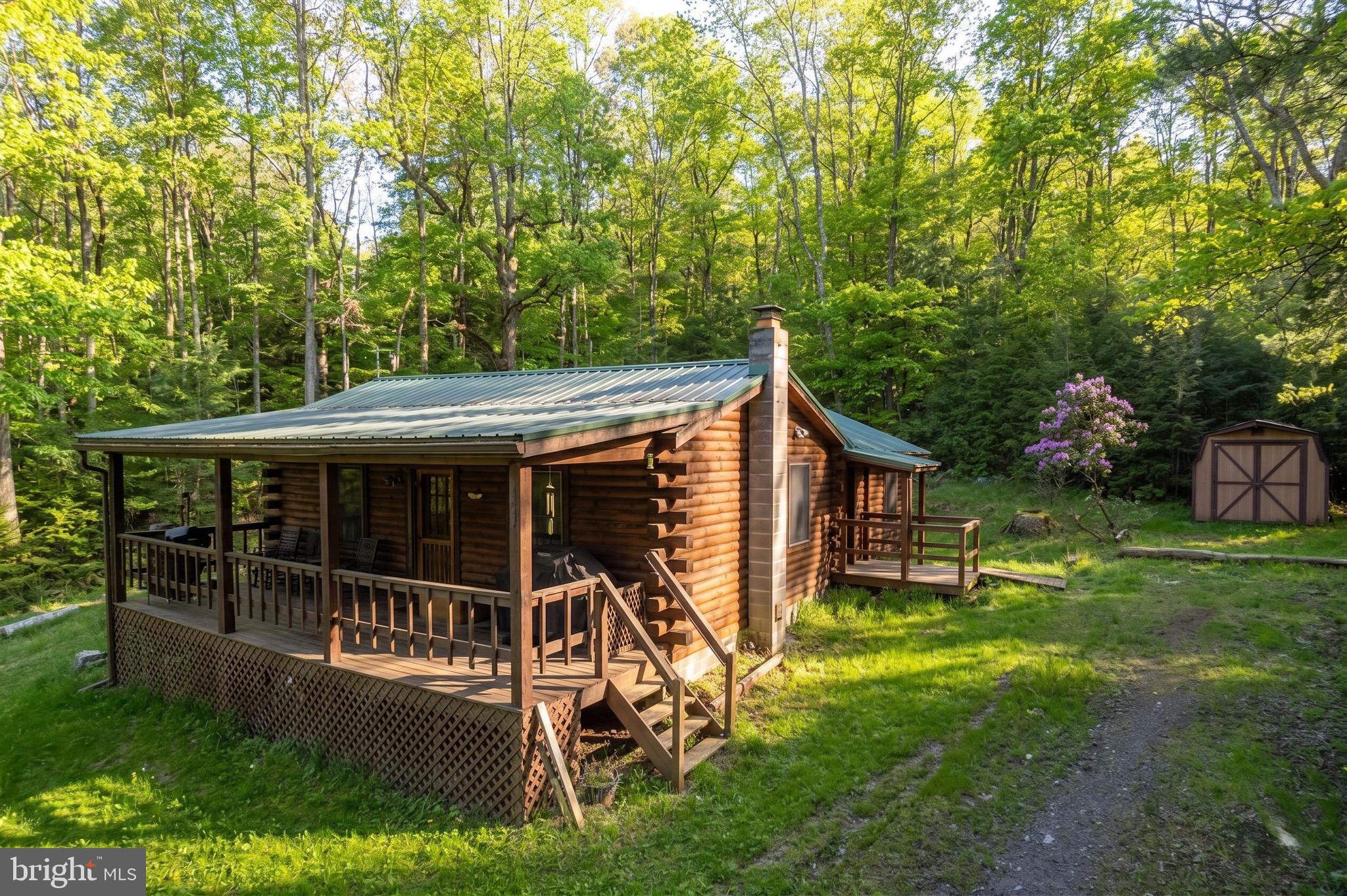 Tucked away on a private lane and surrounded by the beauty of the woods, this charming 3-bedroom, 1 full bath and 1 half bath log home offers the perfect mountain retreat on 2 peaceful acres in Garrett County. Ideally located just minutes from Swallow Falls State Park, Muddy Creek Falls, and the Youghiogheny River, this cozy cabin is a dream destination for outdoor enthusiasts seeking hiking, fishing, kayaking, and year-round adventure.

Inside, you’ll find warm rustic charm with comfortable living spaces, a gas fireplace stove for cozy mountain evenings, and a bunk room perfect for hosting family and friends. One of the three bedrooms features its own private half bath and private deck, creating a relaxing escape after a day outdoors. Enjoy quiet mornings and unforgettable evenings from the covered front porch, surrounded by nature and mountain serenity.

Conveniently located only 10–15 minutes from Deep Creek Lake and Wisp Resort, this property offers easy access to boating, skiing, dining, and entertainment while still feeling wonderfully secluded. Priced to be an affordable vacation home in today’s market, this is an incredible opportunity to own the ultimate log cabin getaway in one of Western Maryland’s most sought-after outdoor destinations.