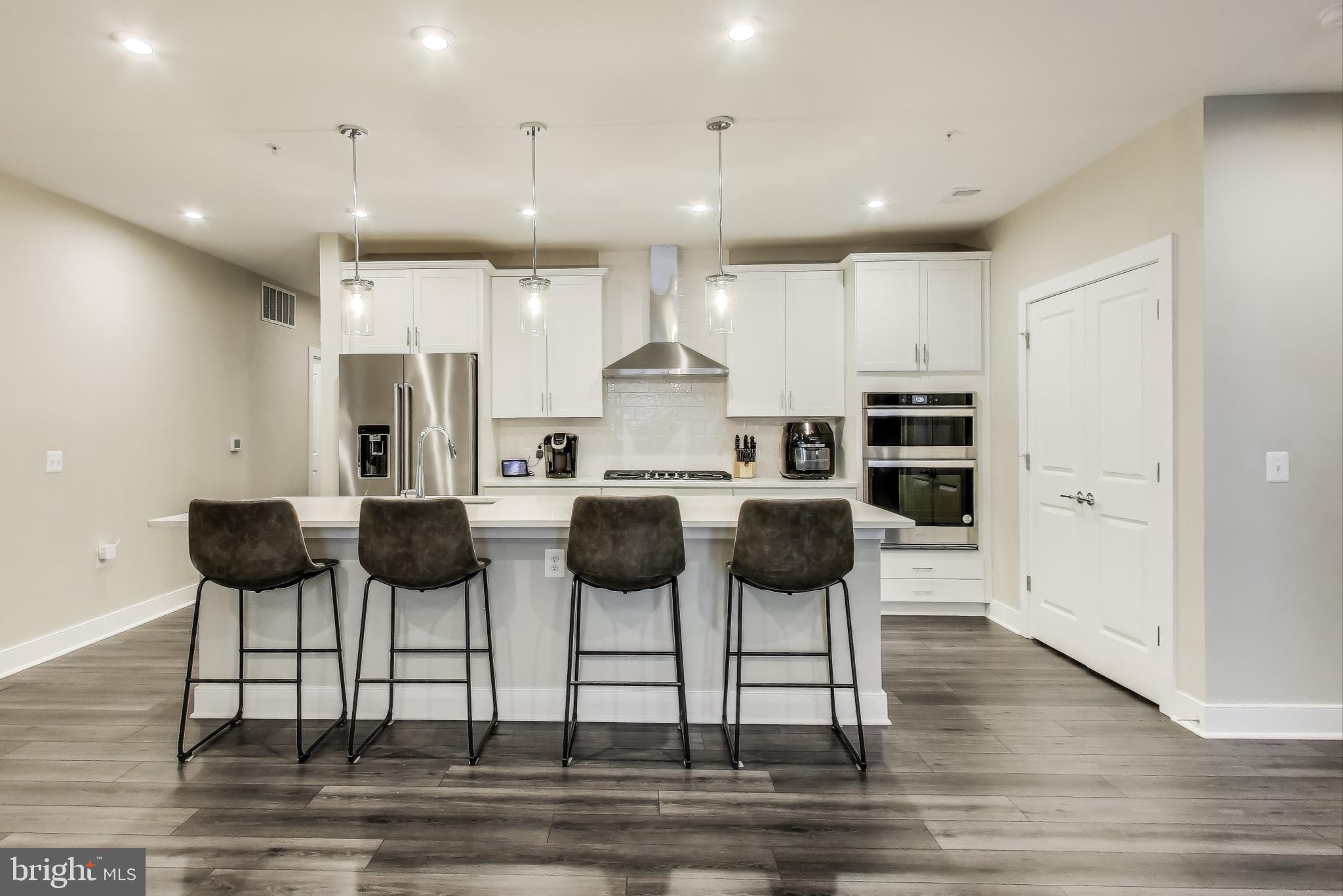 Welcome to a lifestyle of convenience and comfort at this beautiful condo located in the heart of National Harbor. As the largest condo design at The Flats at National Harbor, this expansive 1,798 sf two-bedroom plus den, two-bathroom unit unfolds in an inviting open concept, making entertaining guests or unwinding equally effortless. The kitchen features a sleek island, stainless steel appliances, and a stainless cooktop under a chic hood. The large primary bedroom is replete with an ensuite bathroom that boasts a walk-in shower. Both bedrooms feature walk-in closets custom-designed by California Closets. The condo extends it living space outdoors with a private balcony, ideal for morning coffees or twilight toasts.  Separate laundry room and multiple storage options underscore the blend of functional design and modern aesthetics. Two assigned garage parking spots, one with access to an EV charging station, convey with the unit. Book your tour today and come see how luxury, location and lifestyle unite in this amazing property.