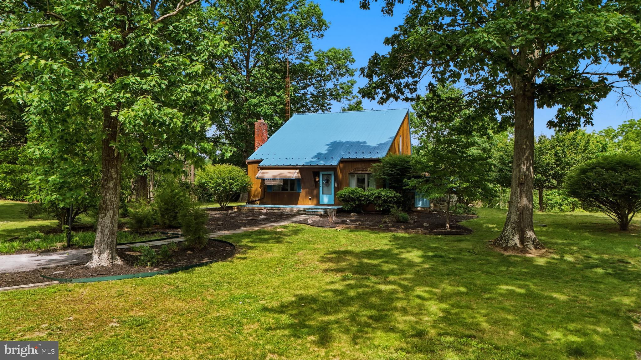 Creekside Cottage Retreat! Enjoy the peace and privacy of this beautifully maintained contemporary cottage situated on nearly 3 acres. With no HOA and animals permitted, this property offers the freedom and space you've been looking for.

Recent updates include newer metal roofs installed within the last 3–5 years. The spacious primary bedroom is conveniently located on the main level, along with the laundry room for easy one-level living.

The inviting great room features custom wood paneling, a brick hearth, and a gas fireplace, creating the perfect space for relaxing or entertaining. A covered and enclosed side deck extends from the living and great room areas, providing additional year-round enjoyment.

Upstairs, you'll find two additional bedrooms and a full bathroom. The former covered porch has been enclosed to create extra closet and storage space.

The full basement offers even more potential, complete with a wood stove flue and brick hearth.

The Oversized 2 car detached garage has electric, garage door openers.