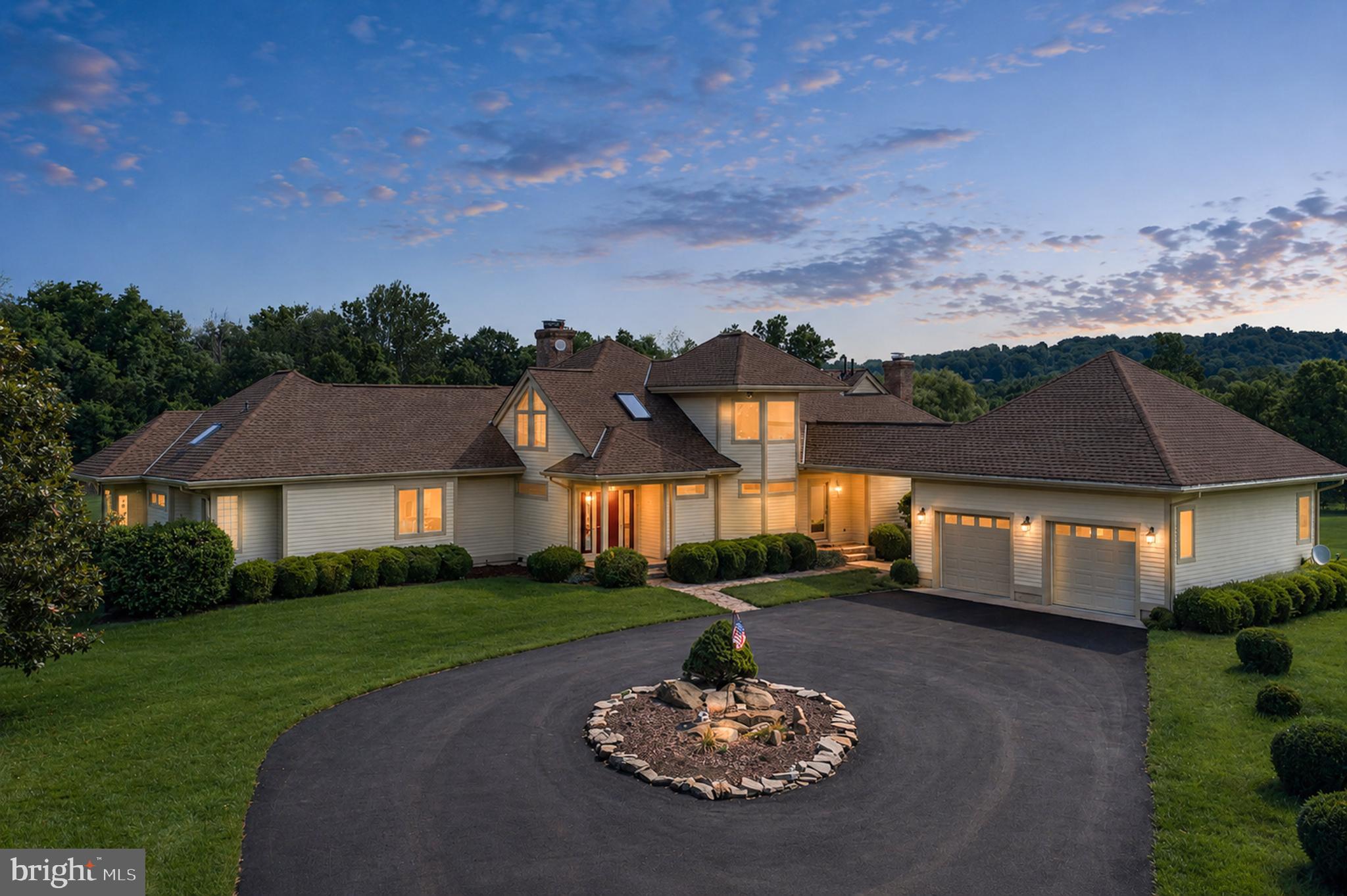 Nestled on more than 16 breathtaking acres in the foothills of the Blue Ridge Mountains, this exceptional estate offers the rare combination of privacy, elegance, and convenient main-level living. Located within prestigious Boxley Farms, a 259-acre conservation of estate properties and NO HOA, the home is surrounded by sweeping lawns, mature trees, lush woodlands, a picturesque pond, and a meandering creek, creating a truly remarkable setting.

A private country lane leads to the custom-built residence, where a circular driveway framed by mature boxwoods and vibrant gardens welcomes you home. Inside, a dramatic two-story living room showcases walls of windows that flood the space with natural light and frame stunning views of the surrounding landscape. A soaring stone fireplace creates a warm focal point, while a formal dining room shares the beauty of a see-through fireplace and vaulted ceilings with indirect lighting.

Designed for both everyday living and entertaining, the gourmet country kitchen features a granite center island, breakfast bar, premium Sub-Zero refrigeration, Wolf 5-burner gas range with wok and commercial-grade copper hood, Gaggenau steamer, dual sinks,  granite and corian countertops, and glass tile backsplash. The adjoining sitting  room / kitchen table area offers a floor-to-ceiling fieldstone wood burning fireplace and beautiful views of the property's abundant wildlife.

The thoughtfully designed floor plan includes two main-level bedroom suites, providing exceptional convenience and flexibility. The luxurious primary suite serves as a private retreat with expansive windows, a separate library, 2 walk-in closets, and a spa-inspired bath featuring a whirlpool tub, large shower, and glass block accents. A second main-level bedroom suite is ideal for guests who don't care for stairs. Additional main-level features include a powder room, large  walk in pantry, laundry room, and covered walkway access to the oversized two-car garage.

Upstairs, two spacious bedrooms with vaulted and beamed ceilings, skylights, and walls of windows. A shared full bath are complemented by an additional library or reading loft.

The walk-out lower level is designed for entertaining and relaxation, offering a spacious recreation room with wood-burning stove, a bonus guest room/ gym and full bath, and an impressive temperature-controlled wine cellar with adjoining tasting room. Large glass doors open to a terrace overlooking the private grounds.

Outdoor living is equally impressive, with a stunning rear deck and terrace accessible from the main living areas, creating seamless indoor-outdoor enjoyment. Fine finishes throughout include gleaming hardwood floors, Italian tile, multiple skylights, and beautifully crafted stone fireplaces.

Equestrian / animal enthusiasts will appreciate the nearly new custom Amish-built two-stall barn, thoughtfully designed with a tack room, hay and equipment storage, attached run-in shed, and an electronically controlled staircase providing convenient access to the hay loft.

Offering the peace and beauty of country living without an HOA, this extraordinary property is just minutes from the village of Bluemont, the Bluemont Community Center for classes, local wineries, farm markets, and Route 7 direct access less than a mile away for super convenient commuting. Conveniently Prime location is only 6 miles from Purcellville and 34 miles to Dulles Airport. This is a rare opportunity to own a private estate in one of Western Loudoun County's most sought-after locations.