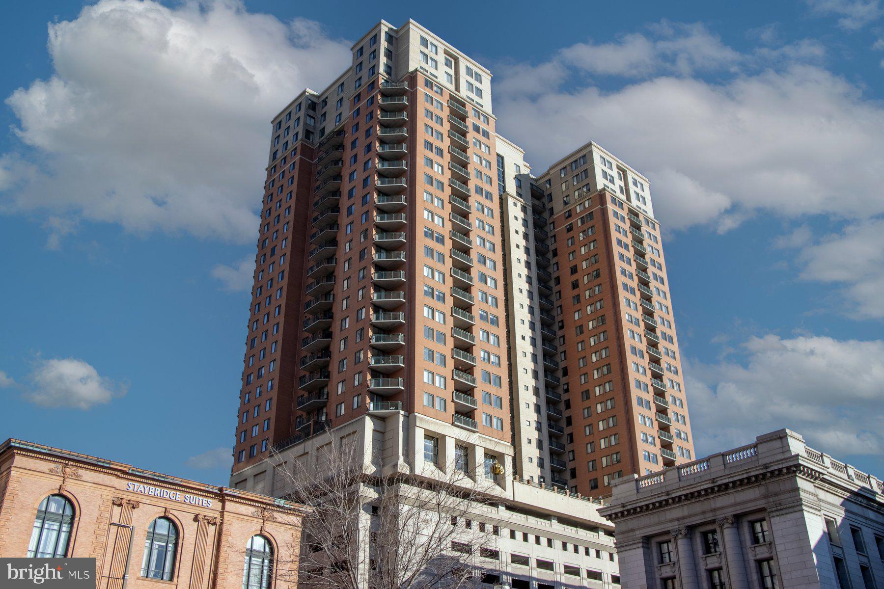 Luxury Condo living awaits you featuring a 2BR/2BA high rise unit with stunning views of the Baltimore skyline. Step into a beautifully maintained secure building, take the elevator to the 25th floor, and make your way to the door into your new home.  The open concept floor plan offers a large living room with a gas burning fireplace, a spacious dining area, and a kitchen. The kitchen features plenty of cabinets including a separate pantry cabinet, granite countertops with a complimenting tiled backsplash, and a stainless sink under a raised breakfast bar.  Down the hall is a spacious secondary bedroom, a full bath with a deep soaking tub, laundry, and a large primary bedroom featuring a walk-in closet with custom organizers, a second closet, and a private bath with a walk-in shower. Just off the kitchen is a cozy balcony offering stunning views of the surrounding city skyline.  This home is move-in ready featuring recessed lighting and gleaming hardwood floors, and is located in a building offering not one but two pools, a community room with a kitchen and bar, a gym, and so much more.  Imagine all this and in close proximity to shopping, restaurants, and commuter routes. Rare find with two parking spots and additional storage (included in monthly fee)!