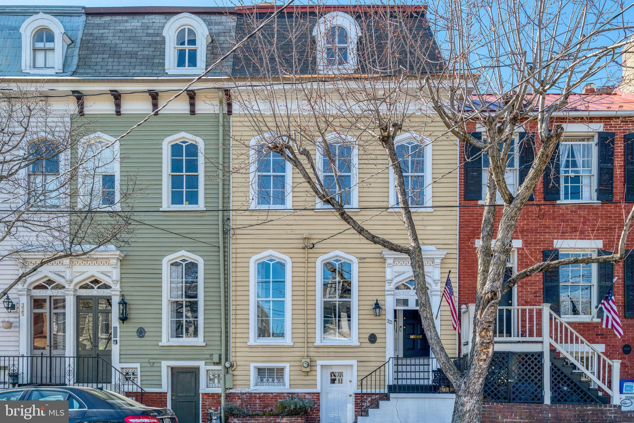 Located in the heart of Old Town Alexandria, 321 S. Pitt Street is an elegant townhome that perfectly blends historic character with modern comfort, ideal for those seeking a refined yet cozy living space in one of the most desirable neighborhoods. Upon entry, you are welcomed into the beautiful vestibule, with a gorgeous transom window. Once inside, wide-plank original wood floors, expansive, fully restored historic windows that stretch from floor to ceiling, and a gas fireplace create the perfect ambiance in this circa 1890 gem. A double parlor and spacious dining room lead to a light-filled gourmet kitchen. It boasts stainless steel appliances, custom cabinetry, and a breakfast nook overlooking the deep garden. This stunning home features three beautifully designed bedrooms, each paired with its own luxurious full bath. The primary suite is a true retreat, boasting a spa-like spacious layout with a classic clawfoot tub, glass-enclosed steam shower, double vanity, and heated towel rack. There are multiple customized closets in the primary bedroom offering abundant storage. A chic lower level with exposed beams and exterior access is ideal for a recreation room, home office, or gym. The thoughtfully designed backyard is a private oasis, with a stylish wood deck extending from the house, offering a perfect space for outdoor dining and relaxation. Beyond the deck, a vibrant stretch of high-quality turf provides a lush, maintenance-free lawn, offering year-round greenery and convenience. Located just steps from King Street’s shops, restaurants, and waterfront, 321 S. Pitt Street offers the perfect combination of historic features, modern amenities, and an unbeatable location. Whether you're looking for a cozy sanctuary or a stylish space to entertain, this home is ready to welcome you.