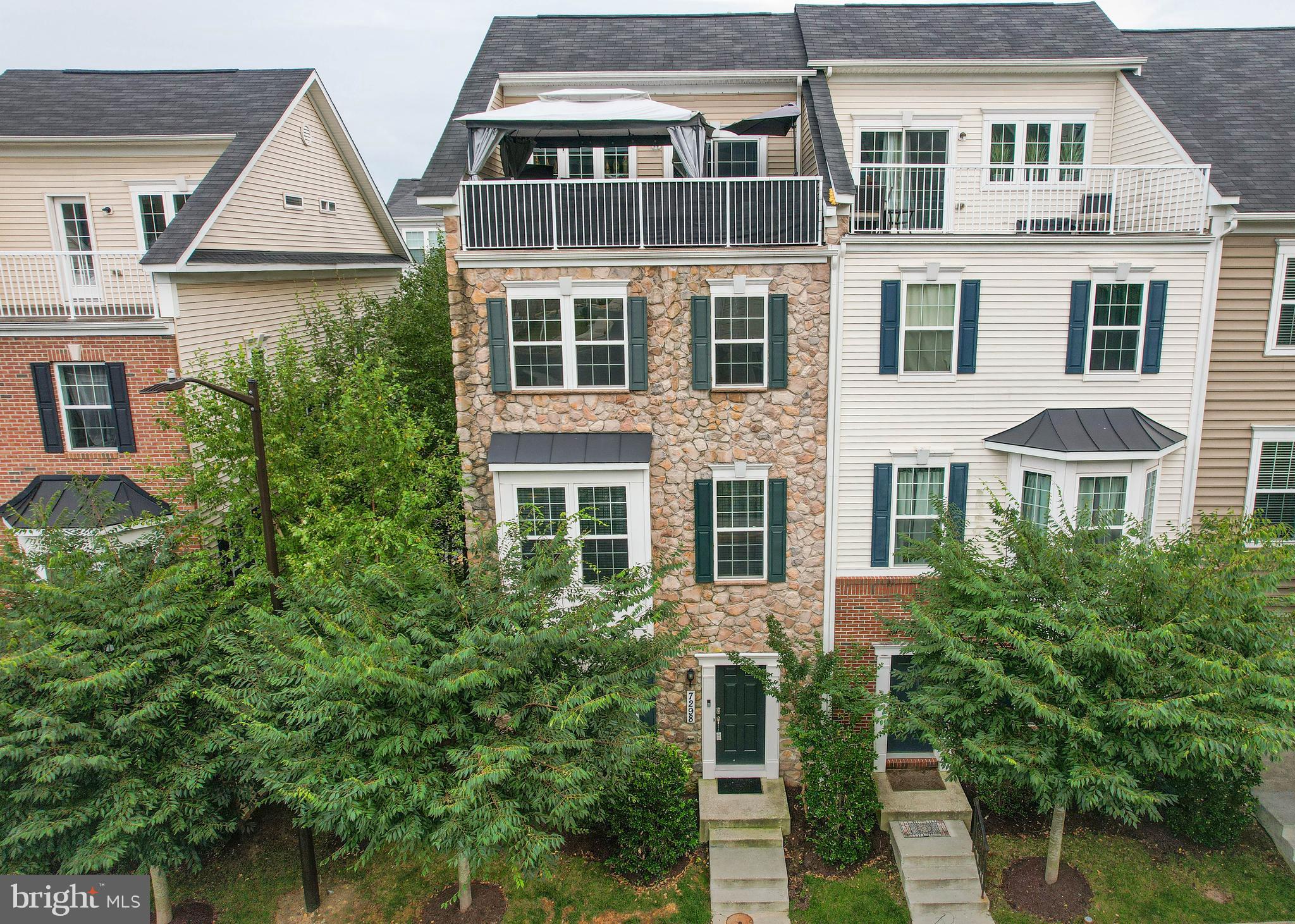 Welcome to effortless luxury in this stunning 4-level, end-of-group stone-front townhome, where sophisticated design meets modern comfort. From the elegant neutral palette to the upgraded fixtures, flooring, and thoughtful touches throughout, this home offers a truly turnkey lifestyle with 3 bedrooms, 2 full baths, 2 half baths, and an attached 2-car garage.

Step inside to a welcoming entry level featuring a spacious family room—perfect for a playroom, home office, gym, or additional gathering space—along with convenient access to the oversized two-car garage.

Rich wood staircase throughout this home leads to each level and first stop  is the beautiful main living level, an entertainer’s dream . The centerpiece is a spectacular kitchen featuring an oversized quartz island with seating for a crowd, undermount sink, gas cooktop, 42-inch cabinetry, pantry, and an abundance of quartz countertop and storage space. The adjoining dining area flows seamlessly into the living room full of natural light, creating an airy, open-concept layout that feels both elegant and inviting. A half bath and access to the rear deck make indoor-outdoor entertaining effortless.

The third level is dedicated to restful retreats. The primary suite offers a walk-in closet and a beautiful ensuite bath complete with a double vanity, oversized walk-in shower, and private water closet. Two additional generously sized bedrooms and an additional hall bath with a tub/shower combination complete this floor.

And then there’s the crown jewel—the fourth-level retreat. This incredible bonus space features a wet bar, lounge area, and sliding glass doors that open to a private rooftop balcony. Whether you’re enjoying morning coffee, evening cocktails, or simply unwinding under the stars, this elevated outdoor escape feels like your own private penthouse oasis. 

Perfectly positioned near Columbia, Baltimore, Washington, D.C., BWI Airport, and Patapsco State Park, you’ll enjoy easy access to shopping, dining, major commuter routes, and endless outdoor adventures.

With luxury finishes, thoughtful upgrades, abundant natural light, and a layout designed for modern living, all that’s left to do is move in and enjoy.