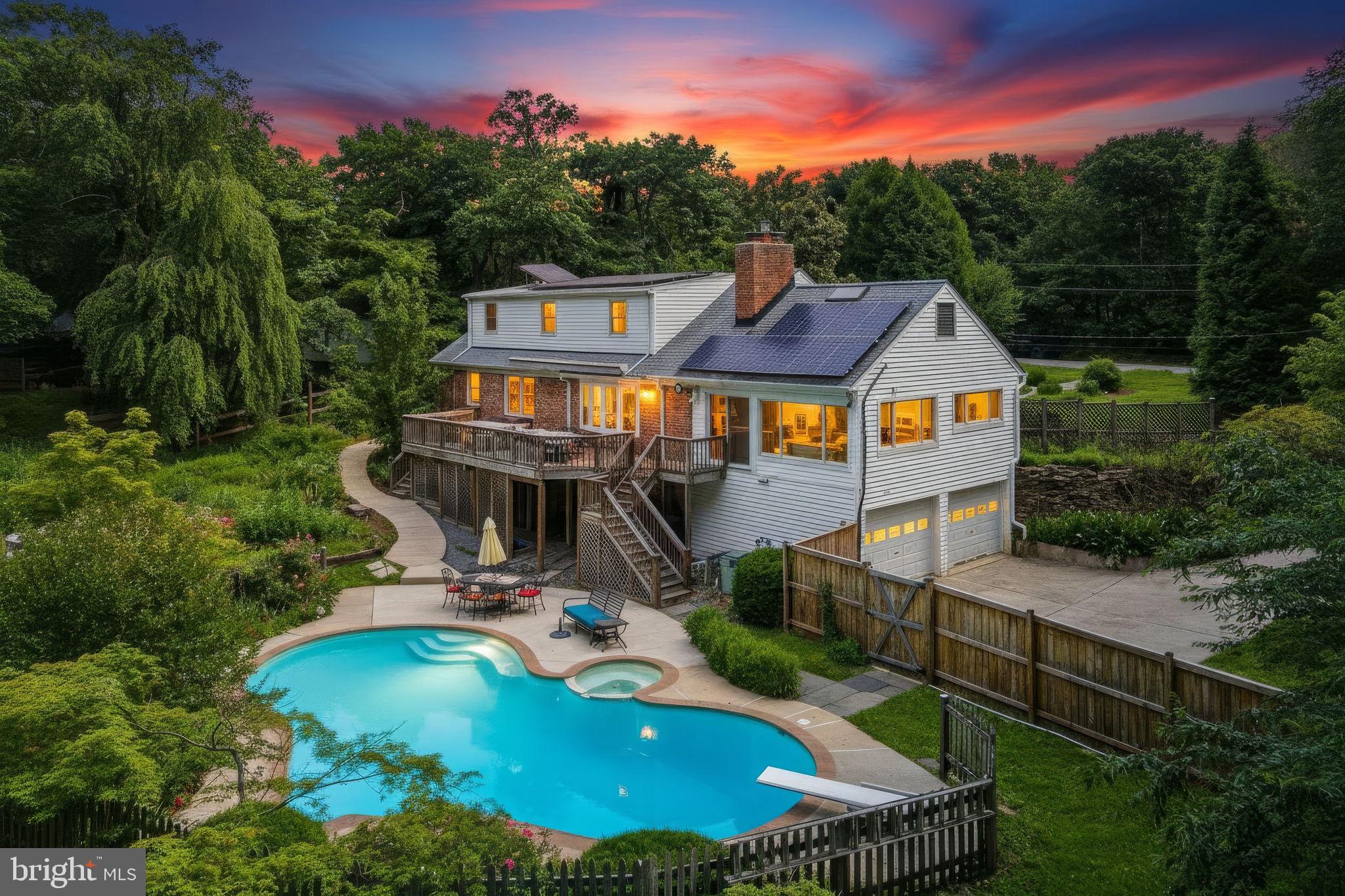 Tucked away on nearly two lush, tree-lined acres in the sought-after Ashton area of Montgomery County, this exceptional property offers a rare blend of privacy, nature, and everyday convenience. Thoughtfully designed for those who appreciate the outdoors, the grounds are a true retreat featuring a stunning wildflower garden, mature fig and pear trees, crape myrtles, a front vegetable garden, and a beautifully integrated in-ground swimming pool surrounded by serene natural beauty. Despite its peaceful setting, the home remains just minutes from shopping, dining, and commuter routes, offering the perfect balance of seclusion and accessibility.

Inside, warm hardwood flooring spans both the main and upper levels, while expansive windows throughout the home invite in abundant natural light and showcase the surrounding landscape at every turn. The welcoming foyer is flanked by a formal dining room and opens directly into the dramatic family room, where a striking wall of windows frames breathtaking backyard views and fills the space with sunlight. A gas fireplace creates a warm and inviting focal point, while glass doors lead to an expansive rear deck overlooking the pool, gardens, and wooded surroundings.

Privately situated on the main level, the spacious primary suite offers a peaceful retreat complete with an ensuite bath. This wing of the home also includes an additional bedroom, a home office, and a convenient half bath, creating flexible living arrangements ideal for guests, remote work, or multi-generational needs.

The kitchen is filled with charm and natural light, featuring skylights, brand-new stainless steel appliances, and walls of windows that create an airy, garden-inspired atmosphere. The adjoining breakfast and sitting area offers a cozy yet spacious setting for casual dining, morning coffee, or quiet evenings surrounded by views of the property. Built-in bookshelves add warmth and character, enhancing the inviting feel of the space.

Upstairs, three additional bedrooms and a full bath provide generous accommodations, along with access to a rare conditioned attic storage space offering exceptional year-round storage flexibility.

The finished walkout lower level expands the home’s versatility with a spacious recreation room featuring  sliding glass doors to the backyard, a bonus room ideal for a den, office, or guest space, an additional half bath, and a dedicated laundry area.

Additional highlights include a two-car side-entry garage, storage shed, solar panels for enhanced energy efficiency, brand-new windows installed within the last year, a water heater less than one year old, a whole-house water filtration system, whole-house generator, and a roof approximately 10 years old.

A truly special property where nature, privacy, comfort, and convenience come together in one unforgettable setting.