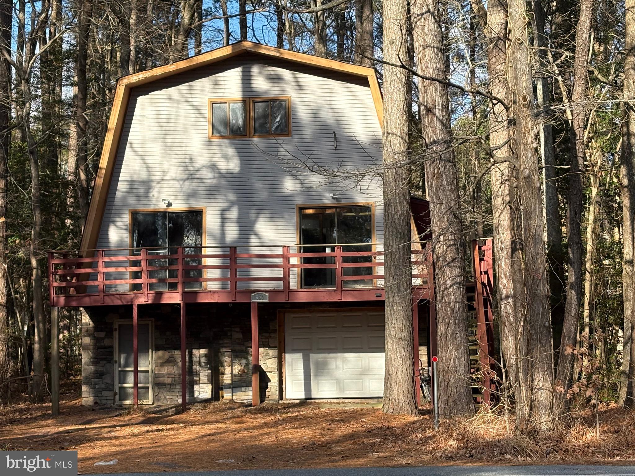 BIG PRICE REDUCTION! MOTIVATED SELLER!  BRING ALL OFFERS! OVERSIZED FLOOR PLAN! You'll feel like you're in the mountains in this Extra Large Home on an Extra Large lot that backs to Parkland!  The second level contains the main living areas, including a tiled backsplash kitchen,  a living room with two story ceilings, balcony access,  and rustic wooden walls. A large 16x12 Bedroom and 11x8 Bath complete the main floor.  Enter the carpeted stairway to a  loft area, two additional bedrooms and a full bath on the upper level, overlooking the living room.  Accommodate the in-laws / grandparents / large families in the Lower Level living quarters with an additional bedroom, bath, laundry room,  kitchen and living area.  A one car garage will store all of your beach gear, toys, and tools! Easy access from the South entrance to Ocean Pines.  Enjoy top-notch amenities and a short drive to the beaches of Ocean City and Assateague National Seashore.  Sold in As-Is condition.