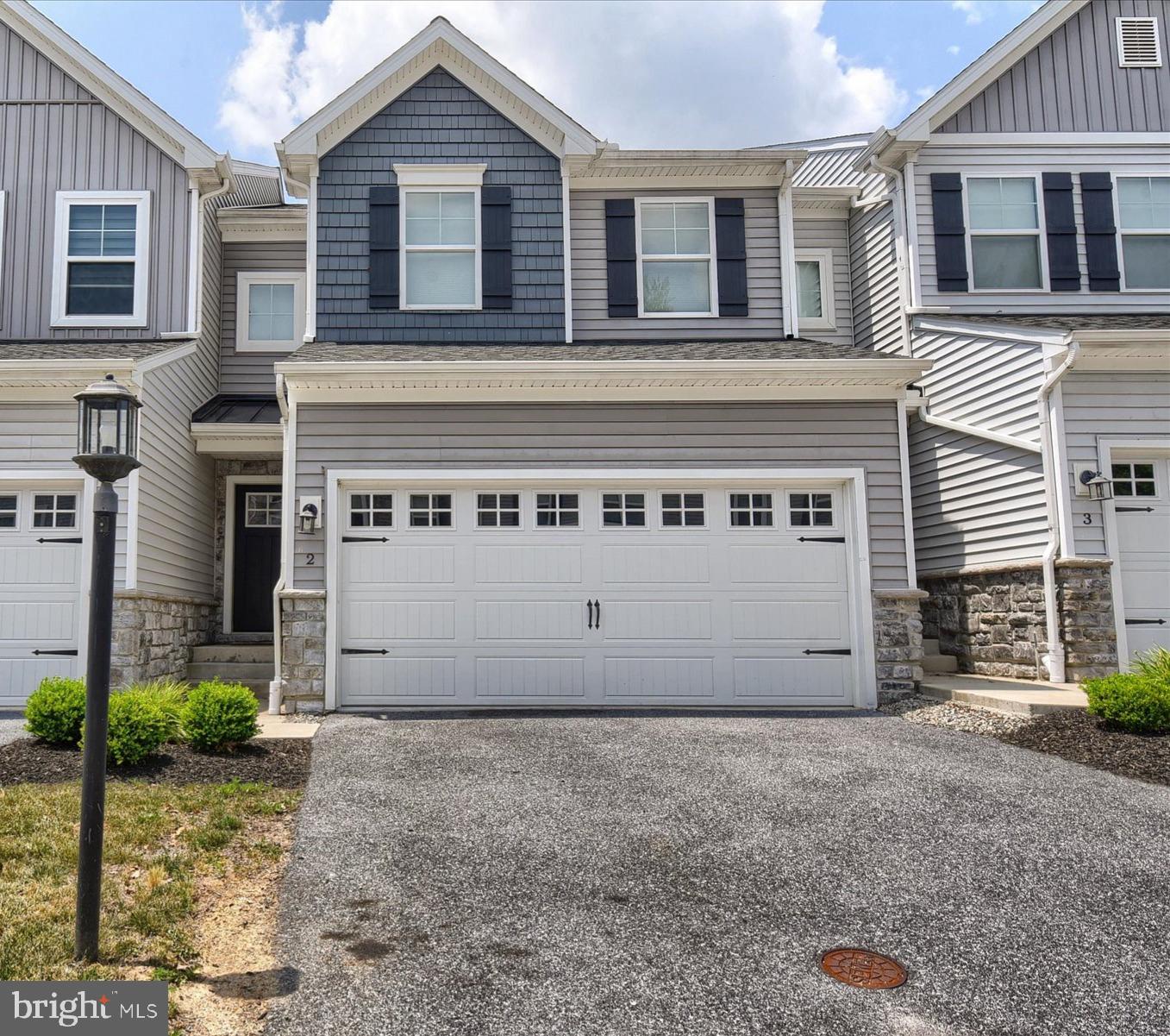 Beautifully appointed townhouse located in a private, 18-residence cul-de-sac community, offering both modern design and low-maintenance living. Built in 2020, this home showcases enhanced curb appeal with carriage-style garage doors, board-and-batten shutters, and charming shake shingle accents. Inside, the thoughtfully designed open floor plan features soaring 9-foot ceilings and an abundance of natural light streaming through a wall of windows in the living and dining areas. The gourmet kitchen is a true centerpiece, complete with quartz countertops, a sleek glass cooktop, double wall ovens, a spacious pantry, and an impressive 7-foot island—perfect for entertaining or everyday living. Enjoy peaceful wooded views from both the main living space and the private rear deck. Upstairs, you’ll find three generously sized bedrooms, two full bathrooms, and a conveniently located laundry area. The owner’s suite offers a refined retreat with a tray ceiling, custom accent wall, walk-in closet, and a luxurious en-suite bath featuring a double vanity and glass-enclosed shower. The walk-out lower level provides excellent flexibility—ideal for immediate use or ready to be finished to your specifications, already plumbed for a third full bathroom. Ideally situated for commuters, this quiet community offers easy access to downtown Harrisburg, major highways, and leading healthcare facilities. Enjoy nearby riverfront dining, recreation, and all the conveniences of the surrounding area.