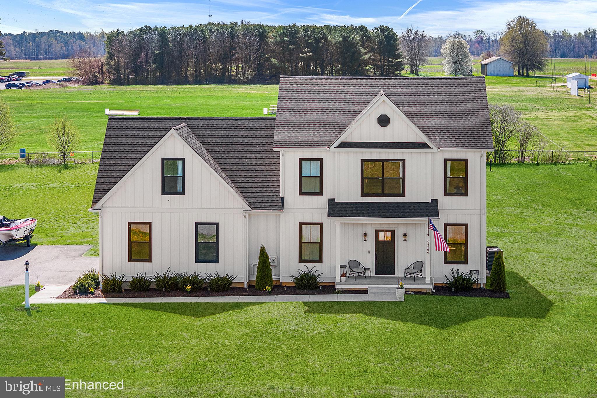 Welcome to this meticulously crafted 2023 contemporary farmhouse, perfectly positioned on a spacious .85-acre lot in the established community of Ashworth. Offering 3,168 square feet, 4 bedrooms, and 2.5 baths, this beautifully designed home blends timeless farmhouse charm with modern finishes and thoughtful upgrades throughout. The striking exterior showcases classic white siding, bold black trim, and expansive windows that create an inviting first impression. Inside, the open-concept layout features luxury vinyl plank flooring, soaring ceilings, and abundant natural light. The great room is anchored by a decorative gas fireplace, offering both comfort and style. The kitchen is designed to impress with granite countertops, stainless steel appliances, a large center island, and a NEW Samsung smart refrigerator. Custom cabinetry, subway tile backsplash, and a pot filler complete the space with both function and flair. Just off the kitchen, the dining area is filled with natural light and opens seamlessly to a spacious deck with a privacy wall—overlooking the expansive, level backyard ideal for entertaining, play, or relaxing. Upstairs, generously sized secondary bedrooms share a well-appointed hall bath, while the primary suite offers a peaceful retreat with a large walk-in closet and spa-like bath featuring a double vanity, custom tile flooring, and an oversized shower. A NEW GE smart washer and dryer are conveniently located on the bedroom level. The fully finished lower level provides flexible space perfect for a home office, gym, or recreation area. The attached sideload two-car garage offers ample parking and additional storage. The home is also wired with Cat6 cable, ideal for modern living, work-from-home needs, and entertainment. Located in the charming town of Ridgely, Ashworth offers a welcoming community setting with convenient access to local shops, dining, and outdoor recreation. Enjoy nearby Martinak State Park with trails, waterfront activities, and scenic picnic areas. Commuters will appreciate easy access to Easton, Denton, Route 404, Route 50, the Bay Bridge, and the beaches of Maryland and Delaware. A perfect blend of quality, style, and location—this is the one you’ve been waiting for.  Mortgage savings may be available for buyers of this listing.