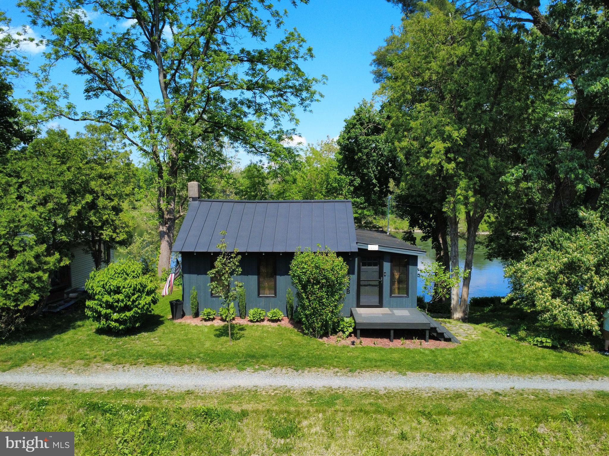 Discover timeless serenity along the picturesque Delaware River! This charming retreat offers a rare combination of privacy, character, and modern comfort, creating the perfect escape from the everyday. The beautifully renovated kitchen blends style and functionality, seamlessly complementing the home’s warm and inviting atmosphere. At the heart of the home, the centrally located living room showcases expansive windows that frame stunning river views, along with a cozy fireplace that enhances the intimate setting. Wake each morning to the tranquil sights and soothing sounds of the river, bringing a true sense of renewal and relaxation. The bedroom suite is paired with a tastefully remodeled full bath, offering a spa-like experience designed for comfort and rejuvenation. Step outside to the rear deck—an ideal setting for peaceful mornings or unwinding evenings overlooking the water. A charming stone path leads directly to the river’s edge, providing easy access for recreation or quiet reflection. Perfectly situated for seclusion while remaining conveniently close to major routes and shopping, this exceptional riverfront property is ideal as a full-time residence or a serene getaway. Experience the beauty, tranquility, and lifestyle that only waterfront living can provide.