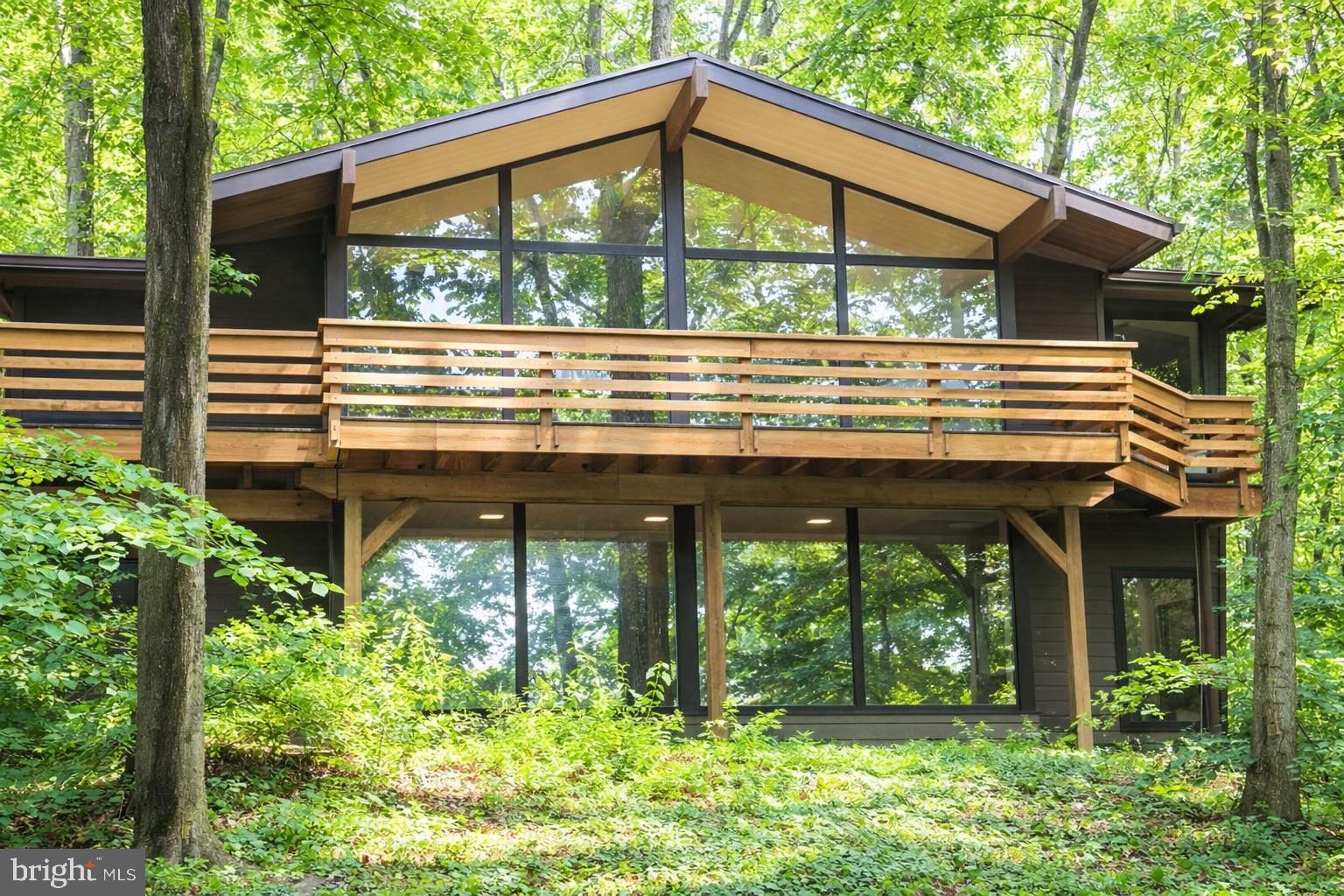 This home will nourish your soul! It has been the privilege of our lives to live in this 2.3-acre McElroy in the T/E school district. Located minutes from VF Park, KOP, and access to major highways, yet nestled in the trees on Valley Forge Mountain, this home offers the best of both worlds. Every day is like being on a vacation, enjoying nature through floor-to-ceiling windows or spending time relaxing by the waterfall by the 30,000-gallon koi pond (which can be converted back to a heated swimming pool if preferred). Or join the VFM swim/racket club, a five-minute walk on the Horseshoe Trail. (With some work, the former tennis court above the pool could be restored or turned into a pickleball court.)

This secluded home has 4 bedrooms, 3.5 baths, a full-house generator, new septic, central air, a gas hot water heater, public water, and PECO natural gas, a 1.5-car garage, Hardie Board siding, and a wired home security system with smoke detection.

The main floor has hardwood floors, exposed beams, and vaulted ceilings throughout, an eat-in kitchen with a 10-foot seamless granite island, DCS 5-burner gas stove, Bosch refrigerator, dishwasher, and convection microwave, as well as a separate pantry, 4 skylights, under-cabinet lighting, and a heated floor, making the heart of this home a joy to be in. The large great room with a gas fireplace and dining room combo makes this a lovely space for family gatherings. 

The very large primary bedroom with a ceiling fan and Jack and Jill vanities boasts more beautiful nature views. Also on the upper floor is a bonus room/office with wrap-around windows, a hallway coat closet, and a powder room with a floating granite countertop and a stone vessel sink. Throughout the upper floor is access to a full-length deck accessed through Anderson doors. The entire floor showcases floor-to-ceiling windows throughout to make the inside feel as one with nature.

Going down the flight of stairs, you enter a large den with floor-to-ceiling wrap-around windows and a wood-burning fireplace. 3 bedrooms and 1 full bath come off the den. The rest of the lower level consists of utility closets, a laundry room with a washer/dryer, and multiple storage areas. The garage enters the house through the laundry room. The garage includes a full bath, which can serve as a mud room.

The grounds behind the house are amazing with slate walkways, a giant koi pond, 10’ tall waterfall sloping up to a former tennis court, and a slate patio perfect for a fire pit.. Surrounding the entire rear property is an aluminum, chain link, and deer fence with a gate exiting onto the Horseshoe Trail. Also in the backyard is a separate “Florida room” with new Anderson windows and doors, so you can sit and feel outside any time of year.

 Ample parking, a recently paved driveway lined with lamp posts, and uplighting will make you proud to arrive home. This beautiful home is move-in ready with fresh paint, new carpet, and a new septic system.