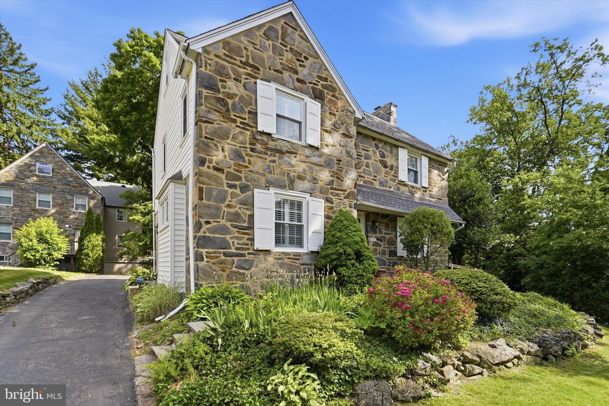Welcome to this beautiful stone colonial in Havertown's Brookline neighborhood! With 4 bedrooms, 3.5 baths and a beautiful secluded yard, this home offers character, desirable amenities and lots of great spaces. Walking up to the home you'll find a private driveway that connects to an attached 2 car garage at the back of the home. A stone walkway leads to the front door, entering into the center entrance hall. Hardwood floors lead the way through a great floor plan that starts with a large living room with gas fireplace, recessed lighting and elegant built-ins on either side of the fireplace. Behind the living room you'll find a den/office space with a first floor half bath and french doors on both right and left sides of the room. To the left leads to the back driveway and garage area, to the right leads to the side deck that overlooks a fenced yard and gardens. Another door gives interior access to the attached garage. The 1st floor continues with a modern kitchen that includes custom cabinetry, stainless steel appliances, granite counter tops, pendent light, large pantry closet and a breakfast bar that opens to the formal dining room. The 2nd floor presents a primary suite with ensuite bathroom, as well as, 2 more bedrooms and full hall bath with tub. A staircase off the hall leads up to a 4th bedroom, as well as, full bath with clawfoot tub and a large unfinished storage room. Stairs off the kitchen lead down to great basement space with one half partially finished with beautiful pointed stone walls, as well as an exit that leads to the driveway. The other half of the basement offers great storage, a laundry area, an the newer gas utilities (Hot Water Heater 2023, Gas Boiler 2023). Other great features include plantation blinds, a door at the top of the 2nd floor hallway that leads out to the railed roof top above the garage and den, a new electrical panel (200 amp), backyard fencing (2023) and smart thermostat. Located in a wonderful sidewalk community, the home offers quick access to schools (Haverford Twp SD - Chatham Park Elementary), local parks, trails along Karakung Drive and Cobbs Creek, Karakung Swim Club, restaurants and stores along Brookline and public transit (high speed line) to Philadelphia and the Main Line. Don't miss this wonderful opportunity!