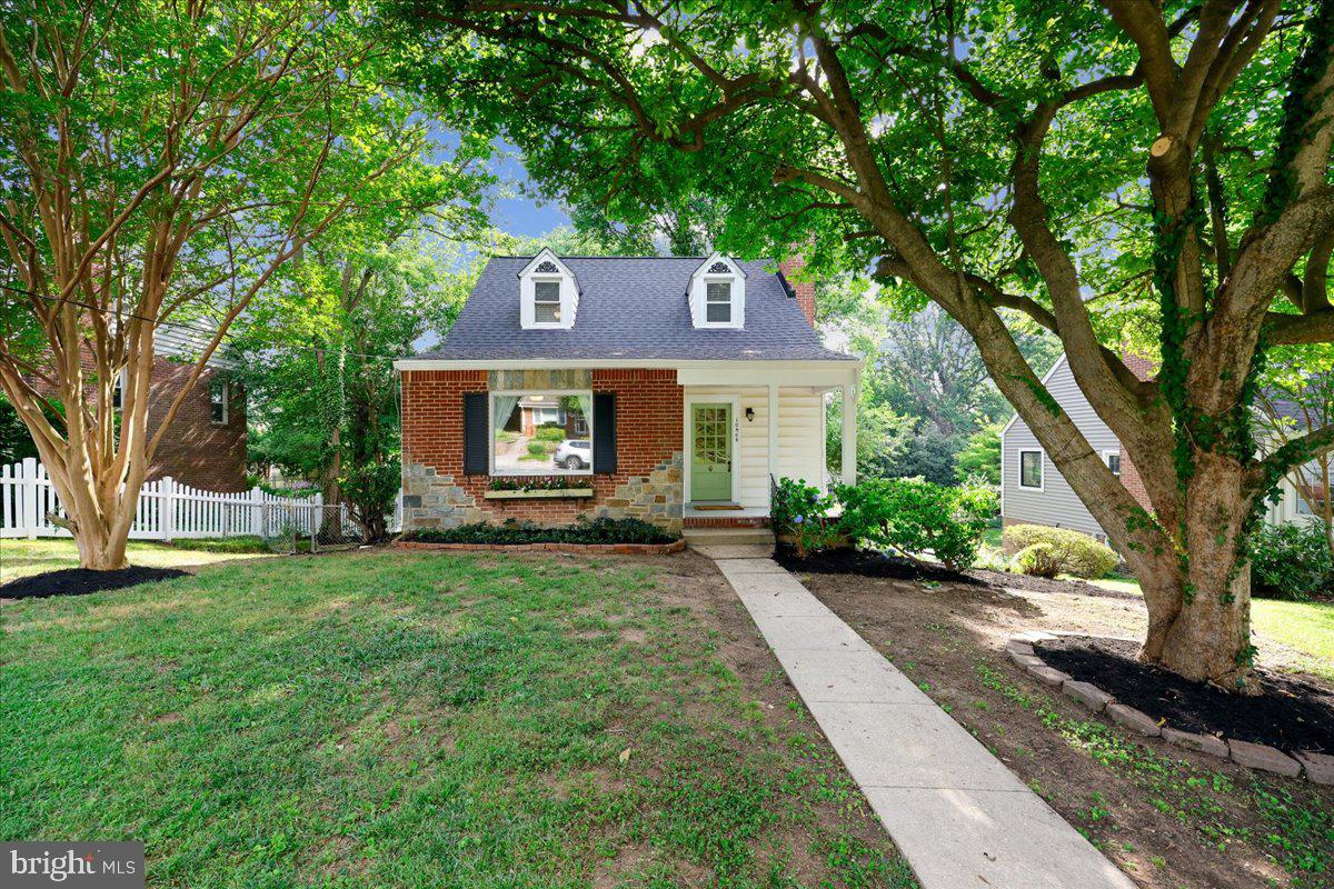 So much to love about this charming storybook Cape Cod! Thoughtfully updated and impeccably maintained, this home features a new roof (2026), oversized gutters (2026), new furnace (2026), replacement windows, and hardwood floors throughout. A welcoming covered front porch leads into the spacious living room, complete with a cozy wood-burning fireplace. The separate dining room opens to an expansive screened porch spanning the entire rear of the home—perfect for relaxing, entertaining, or enjoying the outdoors in every season. The bright, functional kitchen offers abundant workspace, a large picture window overlooking the backyard, and convenient side access. The main level includes a sun-filled bedroom and a beautifully renovated full bath. Upstairs, you’ll find an inviting open hallway with a reading nook and built-in bookshelves, a large cedar closet, two generously sized bedrooms, and another tastefully updated full bathroom. One of the upstairs bedrooms also features a spacious walk-in closet. The clean, unfinished walkout lower level provides exceptional storage, laundry space, and endless potential to create additional finished living space. Step outside to enjoy the large, level backyard from either the lower patio or the expansive screened porch. A private driveway offers off-street parking—an invaluable bonus! Located just one block from the neighborhood park featuring a playground, walking trails, open green space, and a popular farmers market, this home also offers unbeatable convenience. With easy access to Metro, bus lines, and downtown DC, you can enjoy a truly connected lifestyle—no car required, though you’ll be glad to have the private driveway when you do.