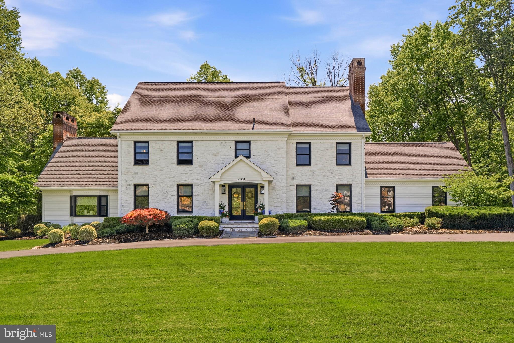 Positioned in the coveted Forest Hill neighborhood, 1234 Forest Hill Drive offers the rare combination of an exceptional location, award winning school district, and a classic home that has been carefully reimagined by the current owners with thoughtful upgrades, designer lighting, and elevated finishes throughout. A circular driveway leads to the slate front porch, where a double front door opens into the welcoming center hall. 
The beautifully renovated open kitchen was designed with both everyday living and entertaining in mind. An expansive quartzite island with seating for six anchors the space and is complemented by a marble backsplash, custom wood-paneled appliances, a GE Monogram six-burner gas range with custom hood and pot filler, and a large picture window overlooking the peaceful backyard. Sliding doors provide seamless access to the rear patio, while a wall of custom built-ins incorporating a pantry and coffee station adds both functionality and convenience to the morning routine. The kitchen flows directly into the family room, complete with custom cabinetry and a beverage refrigerator, creating an inviting gathering space for family and friends.
Just beyond, the spacious living room offers a more tranquil library, featuring a gas fireplace flanked by built-ins and a large bay window overlooking the front grounds. The exquisitely designed formal dining room is equally suited for entertaining and everyday use, a second  fireplace, and built-in cabinetry. An updated powder room with marble vanity and a thoughtfully designed laundry/mudroom with cubbies and storage hooks, along with convenient access to the garage and rear patio, complete the first floor.
The primary suite has been transformed into a true private retreat with new hardwood flooring, updated paint colors, a custom walk-in closet, spacious on suite bath, sitting room or office with a fireplace and a full wall of custom built-ins adds flexibility and warmth to the suite. Three additional bedrooms with generous closet space and updated color palettes, a renovated hall bath with double vanity, and multiple linen/storage closets complete the second floor.
The newly renovated third floor provides excellent flexibility as a bedroom suite or bonus space, offering a brand new full bath with a walk-in shower and a wall of closets. The finished lower level adds even more living space with room for recreation, fitness, or hobbies, along with several storage rooms and an oversized freshly renovated full bath. Additional improvements include a full house generator, new Marvin windows, and new Anderson doors throughout the home, offering both comfort and peace of mind. 
Outside, expansive brick and paver patios create an ideal setting for outdoor dining, entertaining, or simply relaxing in the serene surroundings of the 0.92 acre lot. Mature trees and established landscaping frame the spacious backyard, which offers enough room for a friendly game of football. Conveniently located near local shopping and dining, Whole Foods, Trader Joe’s, major roadways, and the Gwynedd Valley train station, 1234 Forest Hill Drive presents a wonderful opportunity to own a timeless home that has been beautifully updated for modern living within the top-rated Wissahickon school district.