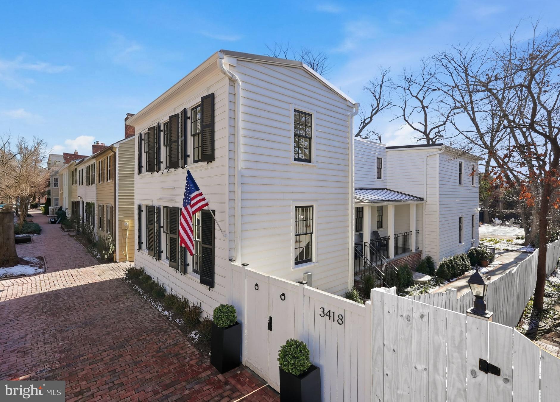 NOW AVAILABLE WITH NEARBY RENTAL PARKING! Set on the block’s largest lot while blending seamlessly with its neighbors, this historic residence at 3418 Reservoir feels like a hidden estate tucked into Georgetown’s West Village. Pass through the charming gate to discover the property’s expansive grounds, where layered greenery and mature plantings create exceptional privacy around the lap pool and terrace, an outdoor space fit for entertaining. Originally built circa 1900, the fully detached Federal home has been completely re-imagined for modern living. A comprehensive transformation—gut renovation, thoughtful expansion, and a full lower-level dig-out—now delivers exceptional scale, including an impressive 9-foot ceiling height below grade. Inside, the home reveals an elegantly fresh design by M.S. Vicas Interiors, showcasing top-of-the-line finishes throughout: a Lacanche range, Waterworks fixtures, honed marble counters and backsplash, white oak flooring, Ann Sacks tile in the foyer, and bespoke cabinetry and millwork crafted to perfection. Four distinct bedroom suites offer privacy without sacrificing character — each with its own charming personality. Outdoor spaces continue to impress with a shaded side porch, a broad rear deck perfect for long-table dinners, and an inviting fire pit completing the exterior offerings. Experience Georgetown like never before as the first to enjoy this refined yet storied residence. RENTAL PARKING AVAILABLE ONLY TWO BLOCKS AWAY!