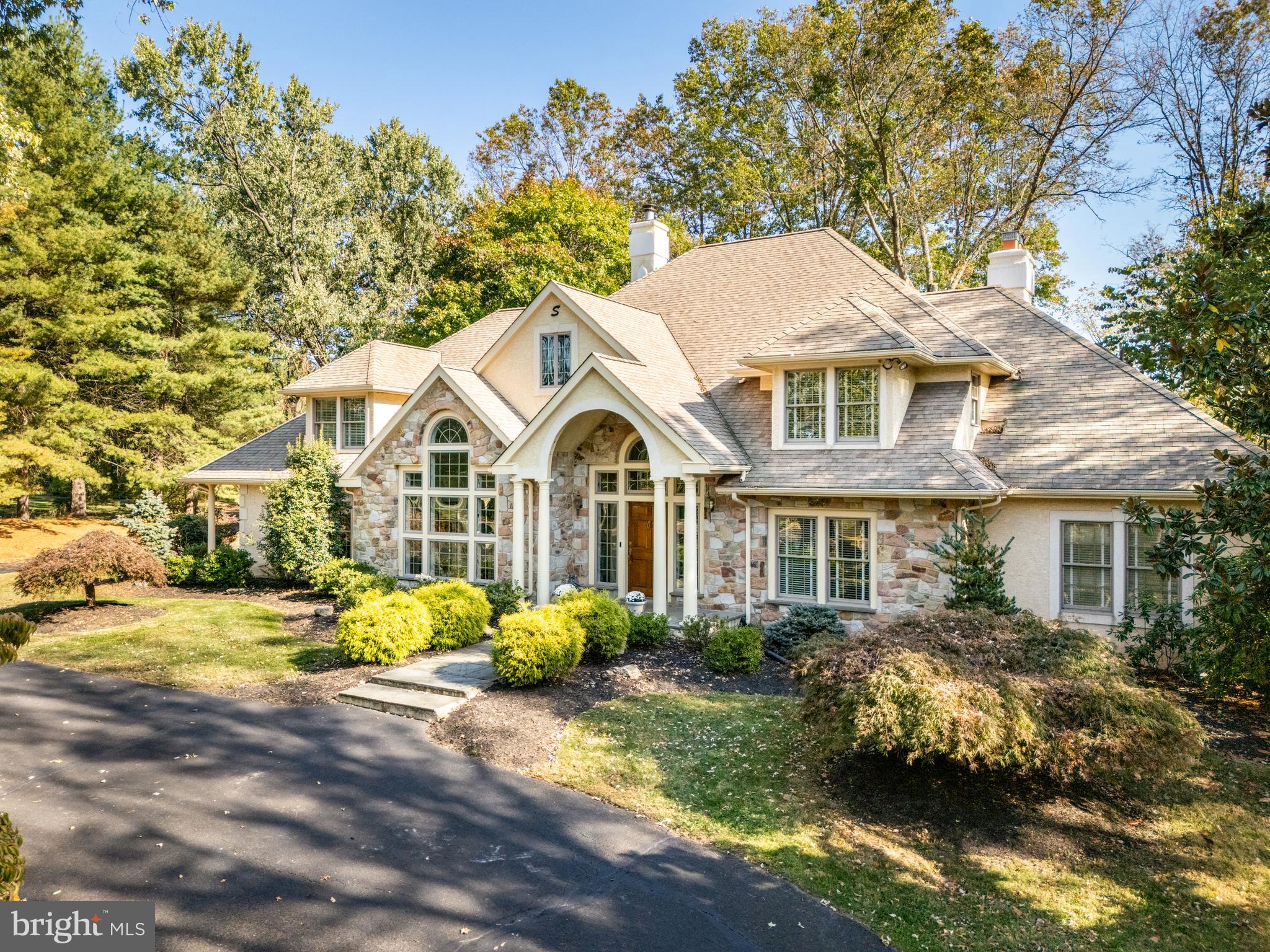 Welcome to 904 Evans Road, an elegant custom built Trueblood French Colonial home nestled in Gwynedd Valley offering over 5,000 sqft of living space. Setback from the road, this tranquil home sits on a level, partially wooded, & tree lined lot of nearly an acre. The horseshoe driveway  featuring custom  light & stonework entryways, provides two distinct entrances, and ample additional parking. This custom home is truly one of a kind, combining a thoughtful design and great flow to the floorplan. A beautifully landscaped walkway guides you to an arched, oversized stone porch, complemented by a gorgeous custom wooden door flanked by glass panels. Step into the inviting two story foyer featuring a sweeping turned staircase & marble floors. To your left, you’ll find a light filled formal living room boasting a stunning custom Palladian window and a cozy gas fireplace.  To your right is an expansive den/library area, complete with hardwood floors and custom built-ins.  If you head straight from the foyer through the custom French glass doors, you'll enter the two-story family room, complete with a floor-to-ceiling stone fireplace, custom built-ins, newly finished hardwood floors, and a breathtaking wall of windows with a second set of custom french doors that open to the slate patio and serene backyard.  The open concept kitchen boasts an oversized island, ample cabinetry, custom appliances, and a delightful breakfast room. Don’t miss the spacious formal dining room, offering beautiful views and its own access to yet another private porch and patio area.  Completing the main floor is an elegant first-floor owner's suite, featuring newly refinished hardwood floors. This suite provides generous space, beautiful views of the back and side yards from every window, a private entrance to the slate patio, a dressing area, an oversized walk-in closet with a shelving system, and a master bath with custom windows, an oversized platform tub, and a large walk-in shower. On the second floor, you’ll find three additional oversized bedrooms, one of which could be used as a secondary owners’ suite, complete with a walk-in closet and ensuite bath. Another expansive  bedroom, complete with a lounge area and its own walk-in closet, provides access to extra unfinished storage. This room shares a Jack and Jill bathroom with the last bedroom, which also includes a spacious walk-in closet. Don’t miss the extra large cedar closet in the upstairs hallway! An added bonus: underneath the carpeting of the second floor is 3/4" unfinished oak hardwood flooring. For those in search of even more space, the finished basement provides multiple entertainment areas, a billiards area, and shelving for wine storage. Need a workshop? This home includes a workshop with its own private outdoor entrance, featuring oversized custom exterior doors! Don't forget to take in the grounds of this lovely home. Here, you can relax to the sounds of birds singing and the gentle rustle of leaves, while also enjoying an ideal setting for entertaining. Conveniently located less than a mile from the Gwynedd Valley Train Station (with a direct line to Center City), this home offers easy access to major roadways, as well as proximity to schools, shopping, and dining. 904 Evans Road is waiting for you to come and make it your own.