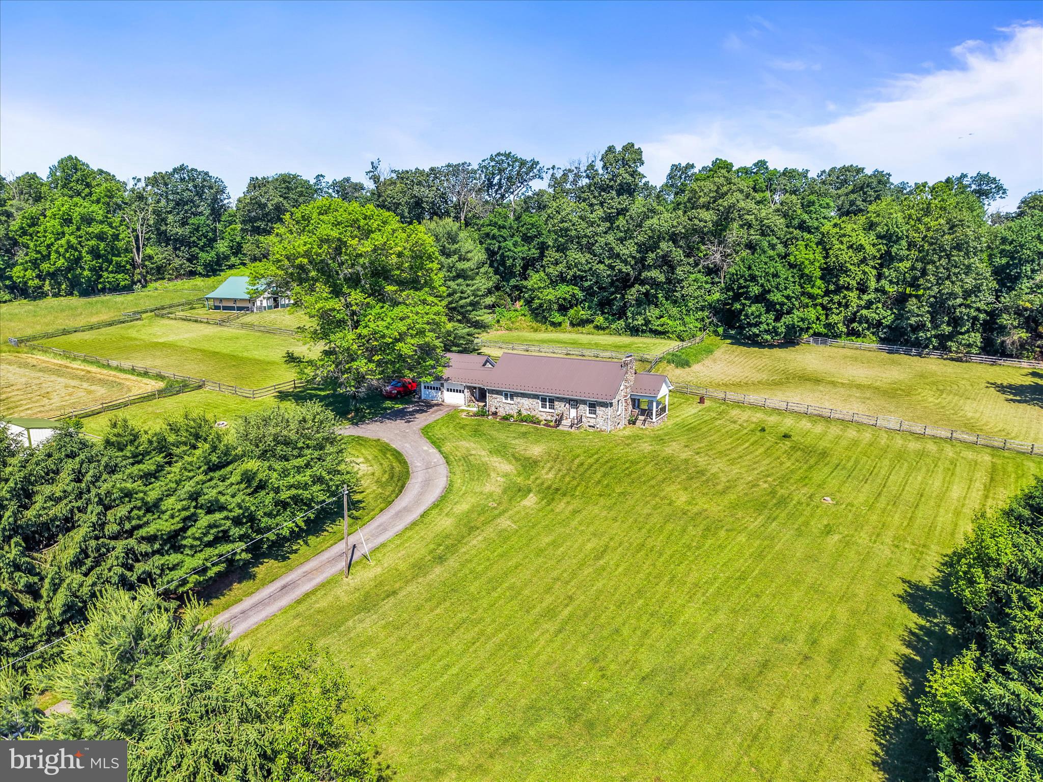 This is a beautiful farm located outside of Spring Grove.  It includes over 27 acres of beautiful land and lots of privacy.    Reasonable property taxes since it is in Clean and Green.  About 1/2 of the land is fairly level and in pasture/hay fields while the other half is wooded.  Most of the pasture area has 3-rail split rail fencing with a strand of electric tape along the top rail.  The rest of the fencing is 3-board fencing.  The barn was built around the year 2000, by Eli Stoltzfus.  The barn has 5 nice sized stalls, a tack room, electric, and water.  There is plenty of room in the loft for hay storage!  You have plenty of room to make riding trails in the woods - for horses, hiking, or 4-wheelers.
The stone house was built in 1953.  It has 4 bedrooms (1 is a walk-through bedroom), 2.5 bathrooms, and 2 stone fireplaces (one has a pellet stove insert and the other has a wood stove).  
There have been many updates to the home:  The metal roof was put on in 2021; the bathrooms on the 1st and 2nd floor were updated in 2025; the den in the basement was finished in 2025.
This property is located between York, Hanover, and the Maryland Line.  There is a grocery store, several restaurants, a gas station, and a post office located less than 3 miles from the farm.