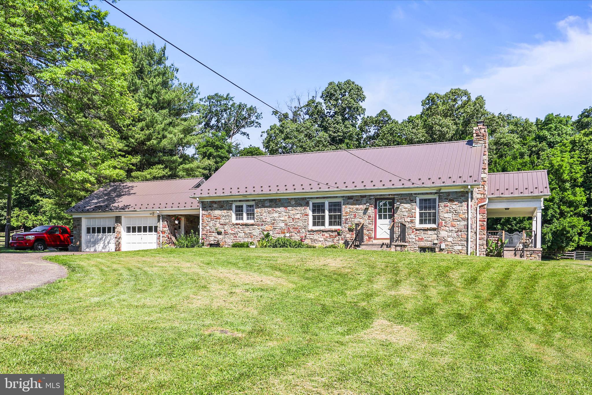 This is a beautiful horse farm with over 27 acres! The stone house sits back a long tree-lined lane, so you are away from the main road, and it makes you feel like you are in your own private world.  The property is enrolled in the Clean and Green program to save on property taxes.  There are approximately 11 - 12 fenced acres (3 rail split rail with 1 strand of electric tape across the top and also 3 board fencing) with 4 separate pastures, and a large hay field. There is a beautiful barn built that was built by the Amish in 2000, with 5 large stalls, a tack room, and a huge hay loft that has held over 700 bales of hay. The barn has electric and 2 frost free water spigots. There is an abundance of wildlife on the property. There are deer that like to play in the front yard and in the woods, wild turkeys, fox, owls, and even an eagle now and then. If you are an outdoor person, the woods are great for hiking, 4-wheeling, hunting/watching the wildlife, etc... The pastures are fairly level while the woods are somewhat hilly. The stone house was built in 1953. It has 4 bedrooms (1 is a walk-through bedroom), 2.5 bathrooms, and 2 stone fireplaces (one has a pellet stove insert and the other has a wood stove). There have been many updates to the home: The metal roof was put on in 2021; the bathrooms on the 1st and 2nd floor were updated in 2025; the den in the basement was finished in 2025. This property is located in the desirable Spring Grove area School District. Its location is convenient to York, Hanover, and Maryland. There is a grocery store, several restaurants, a gas station, and a post office located less than 3 miles from the farm.