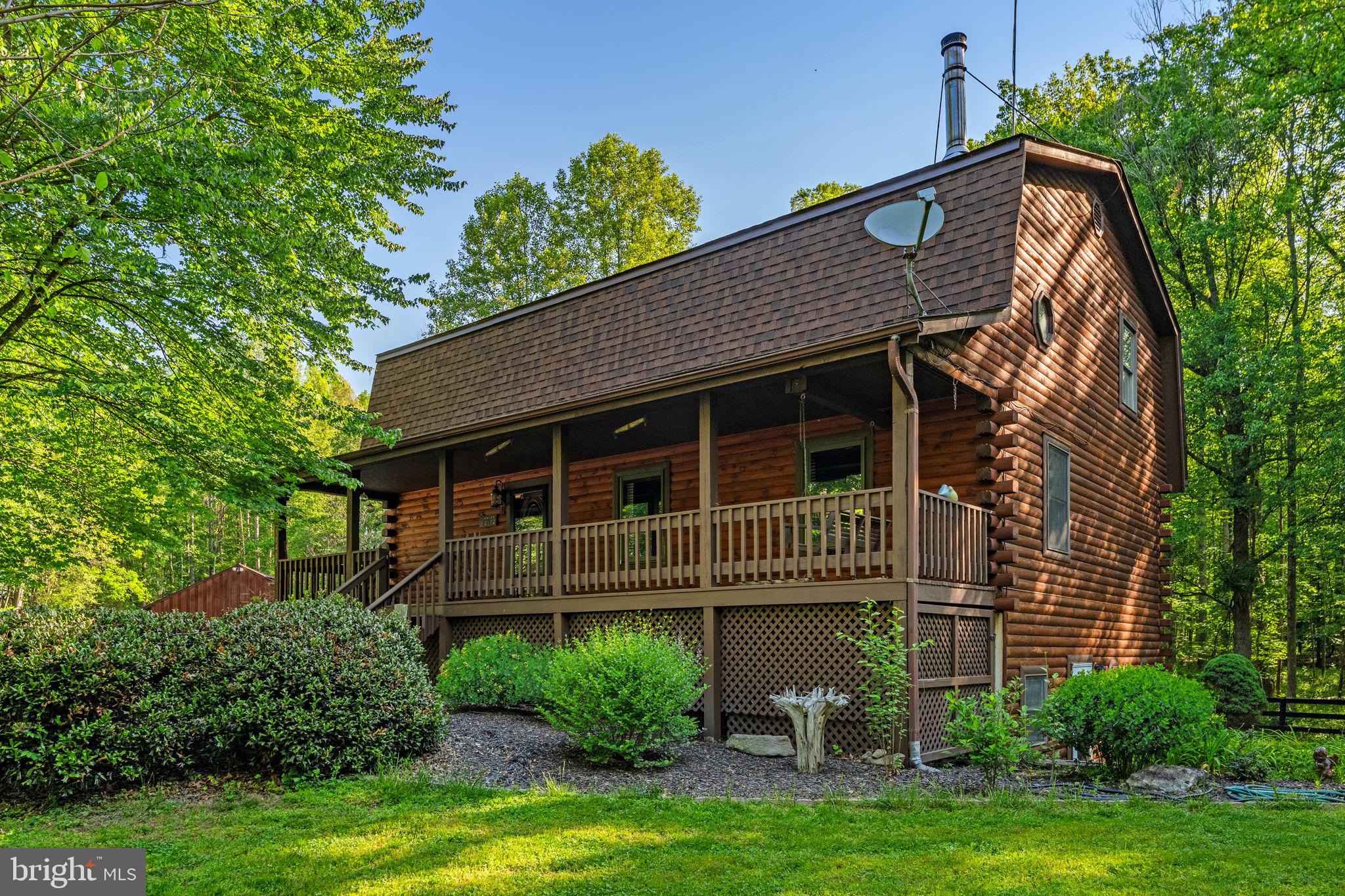 PRICE POSITIONED FOR A QUICK SALE! Incredible opportunity to own a spectacular, solid log home estate nestled on over 8 private, pristine acres, complete with miles of neighboring hiking and equestrian trails! Built with unparalleled craftsmanship, this rustic retreat features soaring two-story vaulted ceilings, exposed beams, and a cozy wood-burning stove that defines country luxury.

MAIN LEVEL & UPPER LIVING:
The main level boasts a spacious bedroom with a full custom bath, a rustic kitchen opening to the deck, and expansive open-concept living and dining rooms. Upstairs, you'll find a massive second bedroom with a private sitting area, a shared Jack & Jill bath, and a generous third bedroom.

BONUS FEATURES YOU WON'T FIND ELSEWHERE:

Independent Lower-Level Suite: Completely self-contained with its own private entrance, full kitchen, bedroom, full bath, and a bright living area with full-sized windows! Absolutely perfect for an in-law suite, multi-generational living, or generating rental income.

Massive Detached Garage: A craftsman or hobbyist's dream, offering endless storage for equipment, a workshop, or toys.

Fenced Yard: Over an acre of securely fenced yard space, absolutely perfect for your four-legged friends to roam safely.

With over 8 private acres, solid timber construction,  and incredible income or living flexibility, this is the best-valued estate on the market today. Come see this magnificent country retreat for yourself!