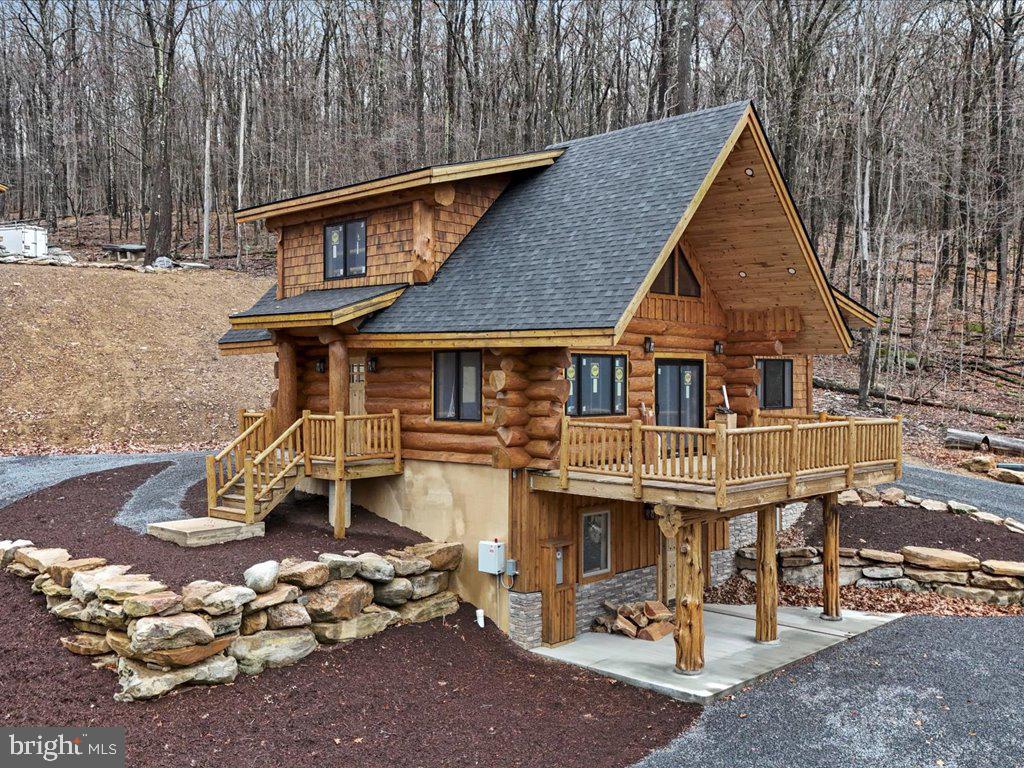 Lake access! Lake views! One of a kind Custom 4 bedroom Log home built with 18” logs, large antler chandelier, custom cedar spiral stairs, indoor and outdoor fireplaces, large deck and covered patio area.  This is a one of a kind property and must be seen in person to appreciate! Wow,  this striking four-bedroom residence stands out as one of the most distinctive homes on Deep Creek Lake.

The main level features a gourmet kitchen with professional-grade stainless steel appliances and granite countertops, complemented by a spacious living room and a cozy family room centered around a wood-burning stove. Step outside onto the expansive 22' x 13' deck to enjoy panoramic lake views.

Upstairs, the primary suite offers comfort and privacy with its own bathroom and serene views of the lake. The lower level includes three additional bedrooms, a full bath, and access to a 25' x 13' patio complete with a wood-burning fire pit — perfect for relaxing or entertaining outdoors.

Every level of this exceptional home showcases beautiful views of Deep Creek Lake, blending rustic charm with modern comfort. In addition, the property offers lake access privileges, providing the full Deep Creek Lake experience.