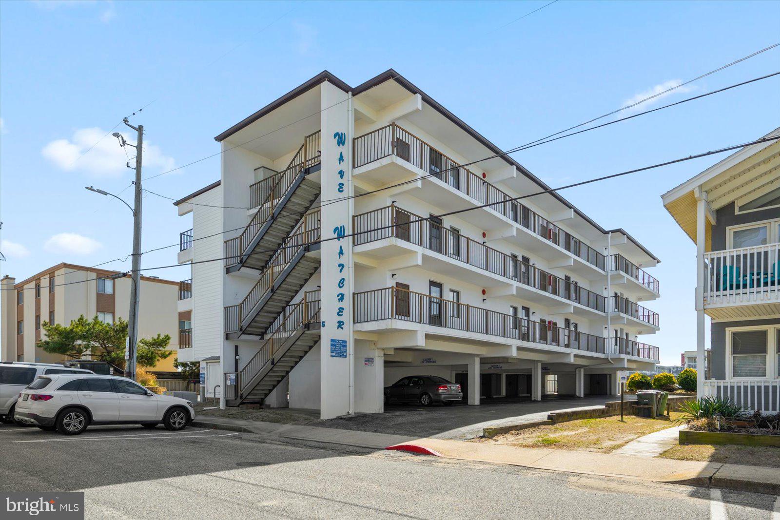 Presenting direct ocean views without the oceanfront price.  This generously sized 2 bed, 2 full bath, top floor corner unit in a well cared for masonry building is just steps to the beach and has views galore. The current owners have used this as a private getaway that has not been rented. Watch the waves from both the living room balcony and the large sized master bedroom.  A nice bay view is also available from the east side common walkway leading to the unit. Electric hurricane shutters for windows and a manual enclosure for the balcony allow you to keep deck furniture in place all year. A brand new HVAC unit with wifi enabled thermostat was installed in December of 2024. The kitchen was recently renovated with granite counter tops, soft close cabinets, and stainless steel appliances.  Both bathrooms have also been fully updated. The master bedroom and living area received new carpet in 2022. An electric fireplace brings an additional level of coziness and a custom wet bar area provides expanded functionality beyond the kitchen. There are remote control ceilings fans in both bedrooms and the living room. The unit also features a full size front load washer and dryer and a large capacity hot water heater.  The unit comes with 2 reserved parking spaces (one under cover) along with an outside storage unit for all your beach gear as well as an outside shower for owners and guests. The midtown location provides quick and convenient access to the route 90 bridge and a low density beach. This well maintained building and well run association allows excellent condo fees bringing down the total cost of ownership. The unit comes fully furnished with a coastal theme. Welcome to the beach!!!