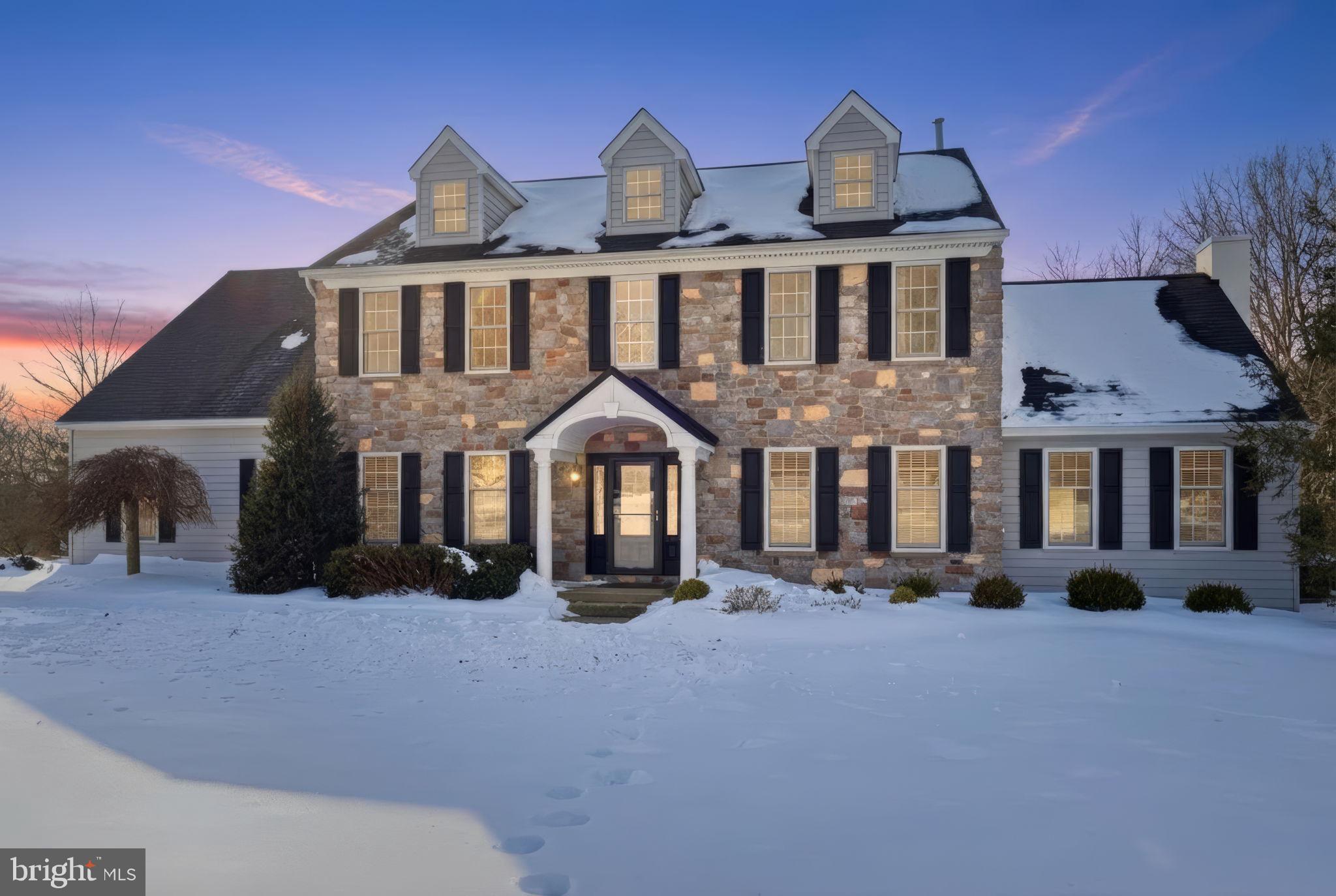 Set on two private acres in the highly acclaimed Central Bucks School District, this exceptional Frank Kelly–built Cambridge Farmhouse model offers timeless elegance, superior craftsmanship, and an unmatched level of detail throughout. Admire the classic stone and siding as you walk in through the covered front door. The colonial is introduced by a striking two-story foyer with a chandelier, shadow box molding, and rich red oak floors finished in mahogany. Designed for both refined entertaining and everyday comfort, the main level features a formal dining room adorned with decorative ceiling molding and medallion, and a sophisticated living room/office with custom built-in workstations and double-door entry. The heart of the home is the beautifully remodeled gourmet kitchen, showcasing custom 42” maple cabinetry, granite countertops, an oversized island, Wolf 5-burner propane cooktop with pot filler, Miele dual ovens, warming drawer, Bosch dishwasher, wine and beverage refrigeration, coffee bar, extensive pull-out storage, and under-cabinet lighting, all thoughtfully designed for culinary excellence. Adjacent to the kitchen is a remodeled powder room and an impressive laundry/mudroom with custom cabinetry, tile flooring, retractable drying rack, exterior access to the backyard, and direct entry to the three-car side-entry garage. The remodeled family room offers a vaulted ceiling, custom feature wall, brand new propane fireplace, Granite leather tile, non combustible wood mantle, built-in speakers, and sliding doors that open seamlessly to the outdoor spaces. The family room is perfect for relaxing. Upstairs, four generously sized bedrooms and two full baths await, including a serene primary suite with double-door entry, a walk-in closet with custom organizers, and a Remodeled spa-inspired bath featuring heated floors, vaulted ceiling, bespoke cabinetry, dual vanities, oversized tiled shower with rain head and body sprays, and a private water closet. A renovated hall bath completes the upper level. The finished lower level spans approximately 1,100 square feet and delivers a true entertainer’s retreat, highlighted by a custom pub-style bar with dual-tap kegerator, commercial ice maker, wine storage, dishwasher, sink, and integrated television. A separate theater/media room with surround sound, a half bath, and plush seating creates the ultimate setting for movie nights and gatherings. Outdoors, the property rivals a private resort. Enjoy a heated concrete/gunite pool with a waterfall spa, expansive multi-level stone patios, ambient outdoor lighting, a built-in wood-burning fireplace, and a 36” Napoleon grill, ideal for entertaining or relaxing in complete privacy. Extensive upgrades include a newer roof, siding, windows, HVAC systems, generator, pool renovations, patios, and more, ensuring peace of mind and modern efficiency. A rare offering that seamlessly blends luxury, lifestyle, and location, this home won't be on the market for long. Be sure to schedule a showing before it's gone!